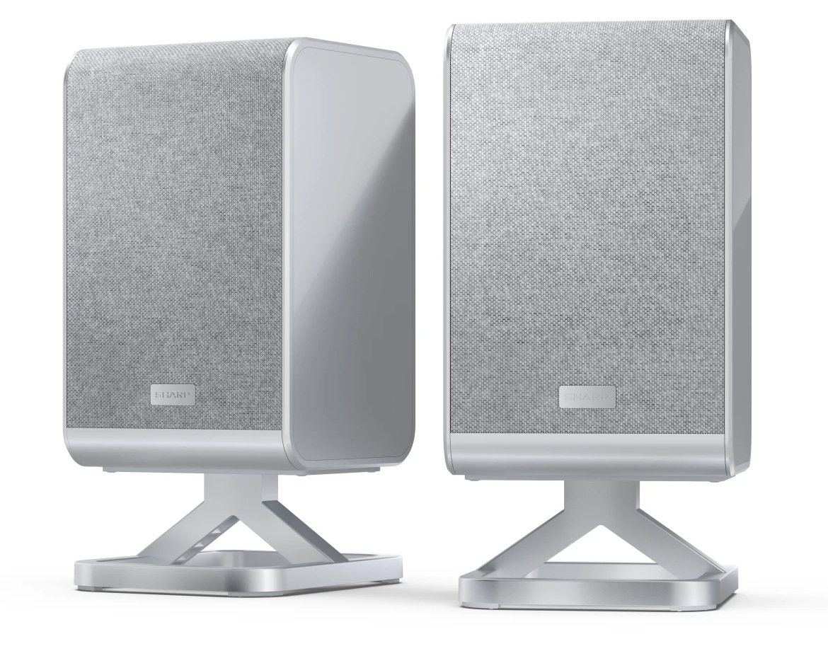 Dwa srebrne głośniki na stojakach. Przód głośników ma szarą tkaninę. Każdy głośnik ma srebrne logo "SHARP".