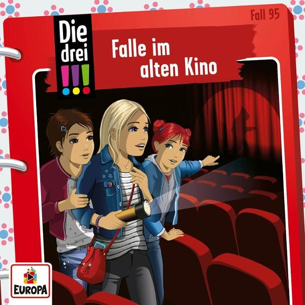 Drei Mädchen in einem Kino, die einen Schatten auf der Leinwand betrachten. Eines hält eine Taschenlampe. Rote Stühle im Vordergrund.