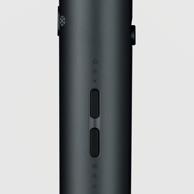 Ciemnoszary cylindryczny obiekt z przyciskami i symbolami. Pokazuje kontrolki zasilania i temperatury. Tło jest gładko białe.