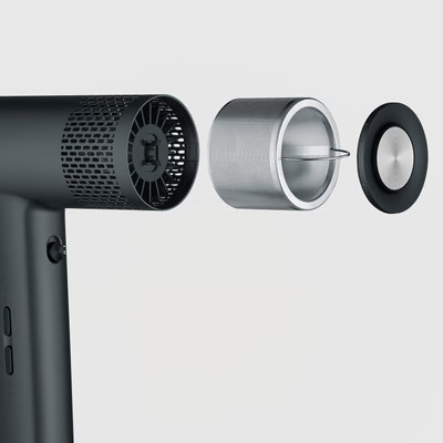 Widok rozłożony czarnego urządzenia z wentylatorem, filtrem z siatki metalowej i czarną nasadką ze srebrnym środkiem na jasnym tle.