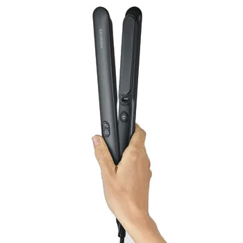 Dłoń trzyma czarną prostownicę do włosów. Urządzenie jest otwarte i ma cyfrowy wyświetlacz.