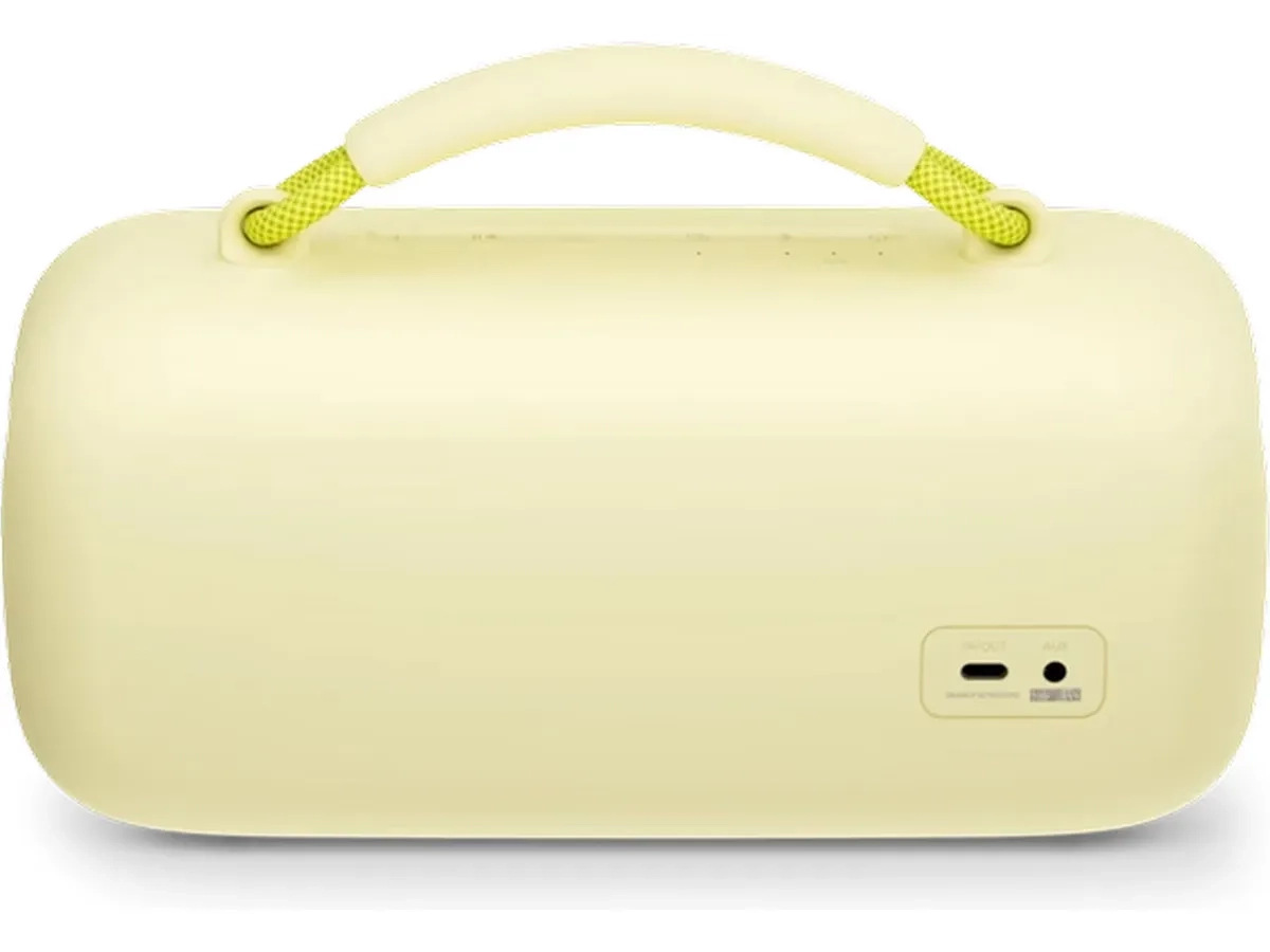 Jasnożółty głośnik z uchwytem i zielono-żółtymi akcentami z liny. Posiada port do ładowania i wejście aux.