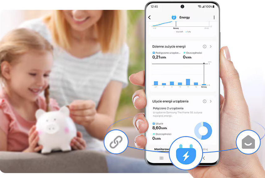 Kobieta i dziecko patrzą na świnkę skarbonkę. Telefon wyświetla dane zużycia energii.