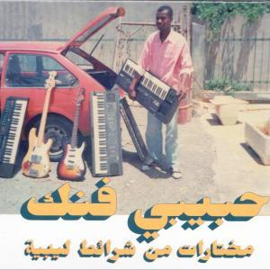 Mann hält Keyboard neben rotem Auto mit Musikinstrumenten. Arabischer Text unten.