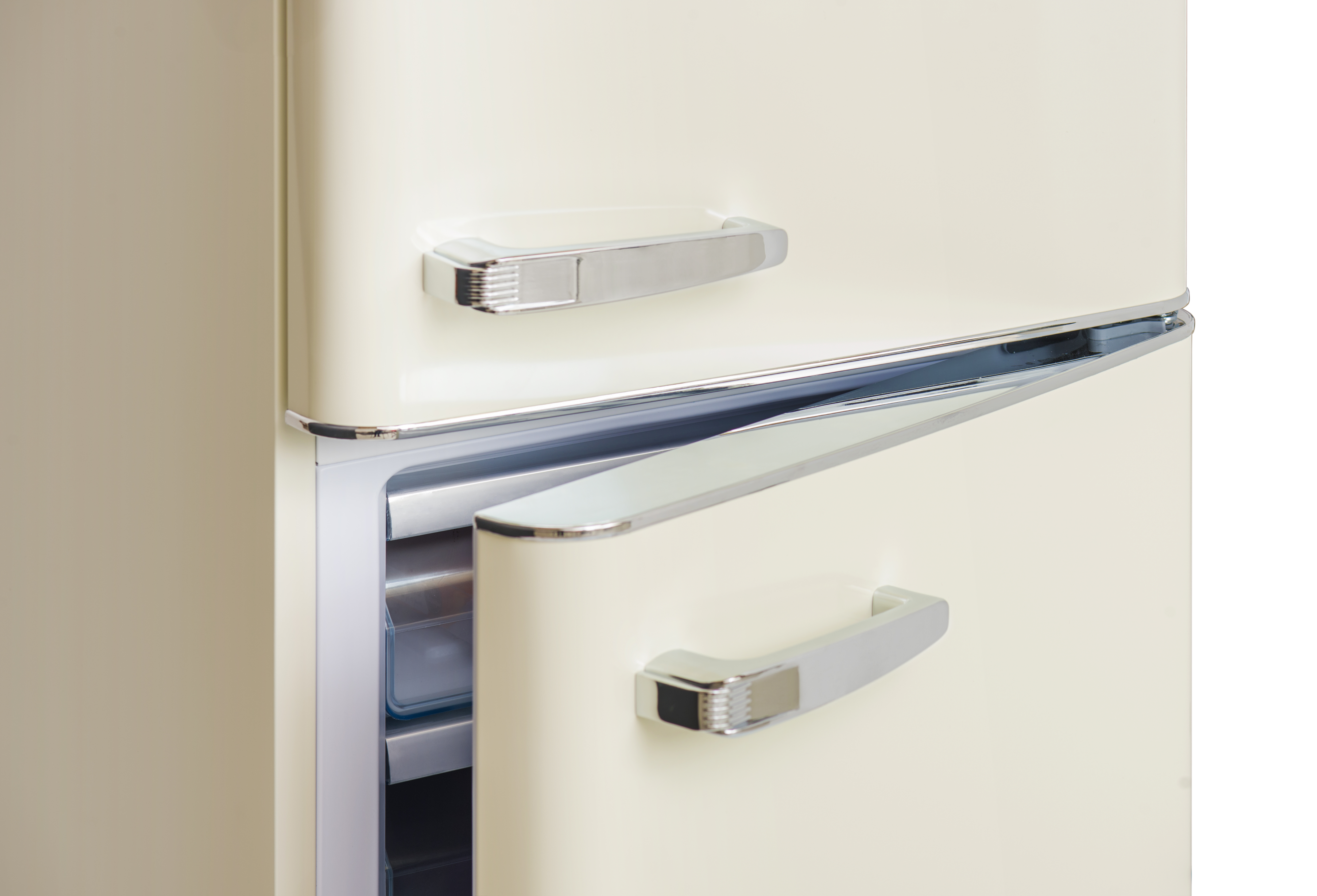 Cremefarbener Kühlschrank mit silbernen Griffen. Die untere Tür ist geöffnet und zeigt das Innere.