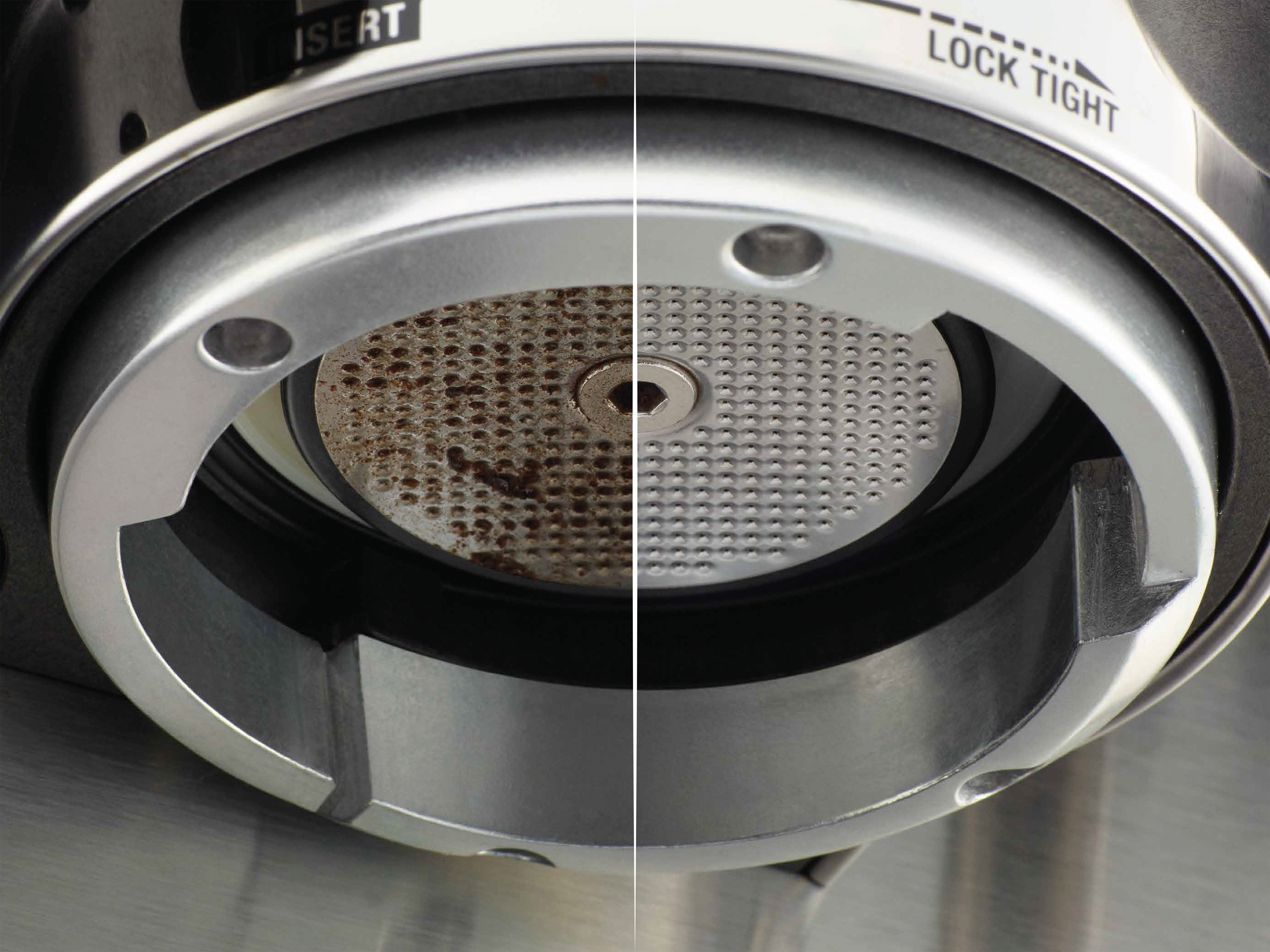 Nahaufnahme einer Kaffeemaschinenkomponente. Eine Seite ist schmutzig, die andere sauber. Metall, Silber und Dunkelgrau.