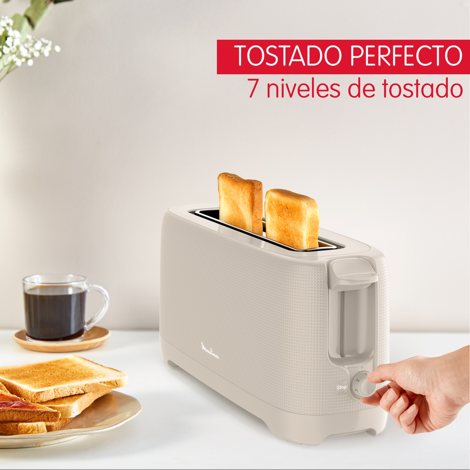 Grille-pain avec deux tranches de pain grillé. Une main ajuste les réglages. Tasse de café et tranches de pain grillé dans une assiette à côté.