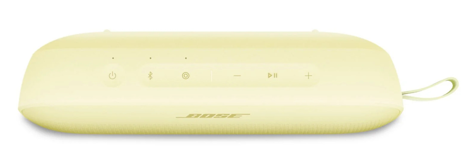 Jasnożółty głośnik Bose. Posiada przyciski i pętlę do przenoszenia. Widoczne jest logo Bose.