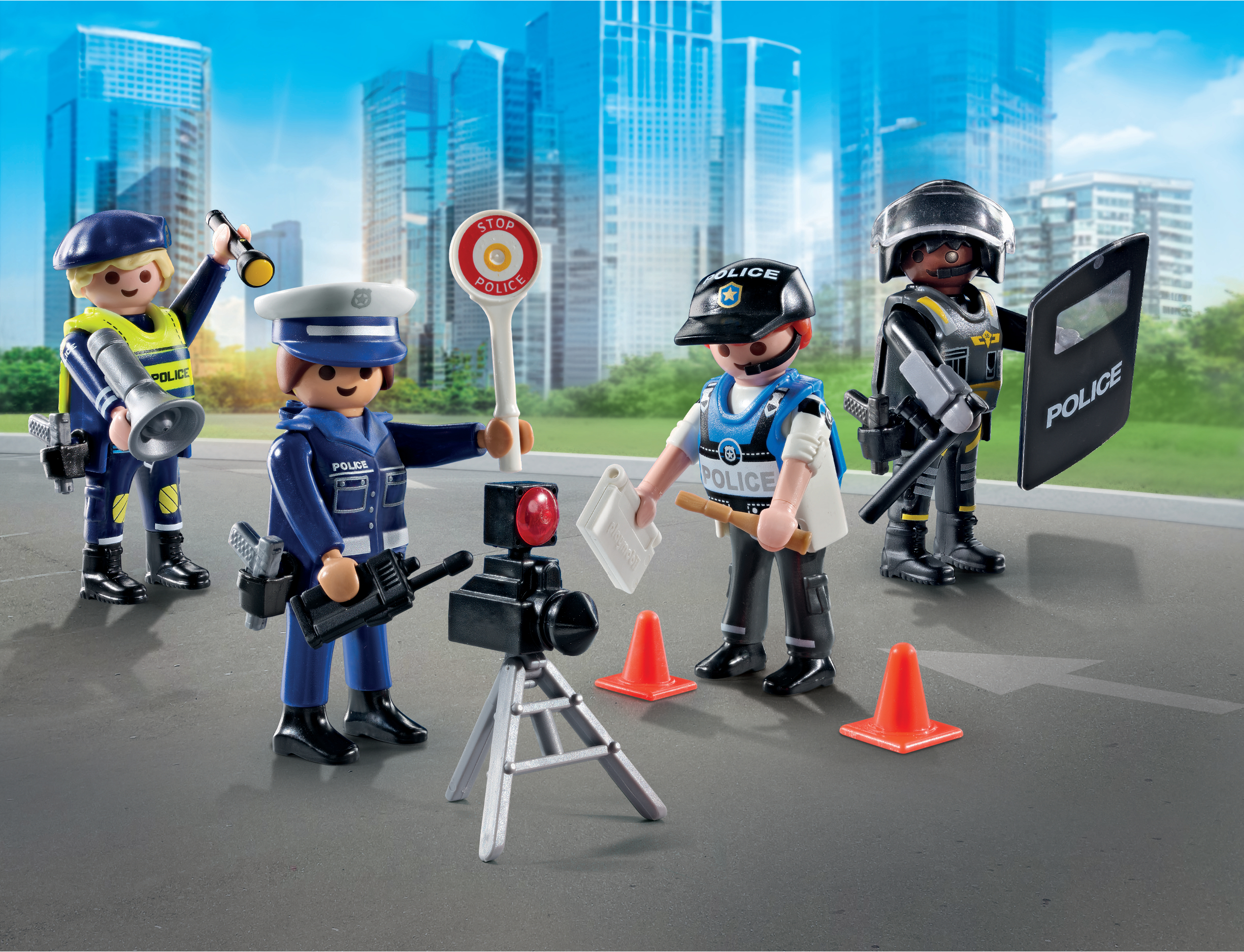 Vier Spielzeugpolizisten in blauen Uniformen stehen auf einer grauen Oberfläche, einer hält eine Taschenlampe, ein anderer ein Stoppschild.