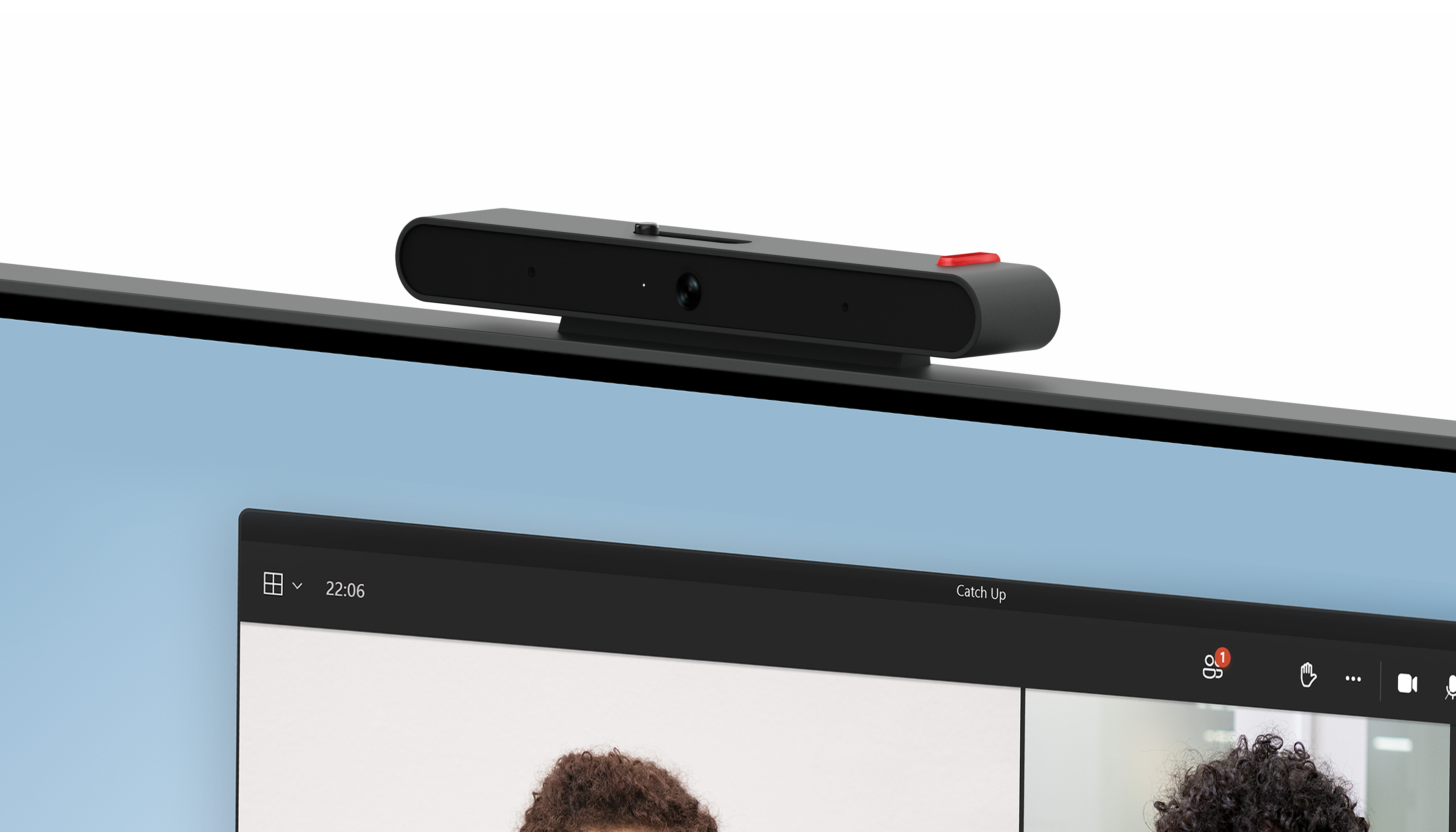Eine Webcam befindet sich oben auf einem Monitor, der einen Videoanruf anzeigt. Die Webcam ist schwarz mit einem roten Knopf. Der Videoanruf zeigt zwei Personen.