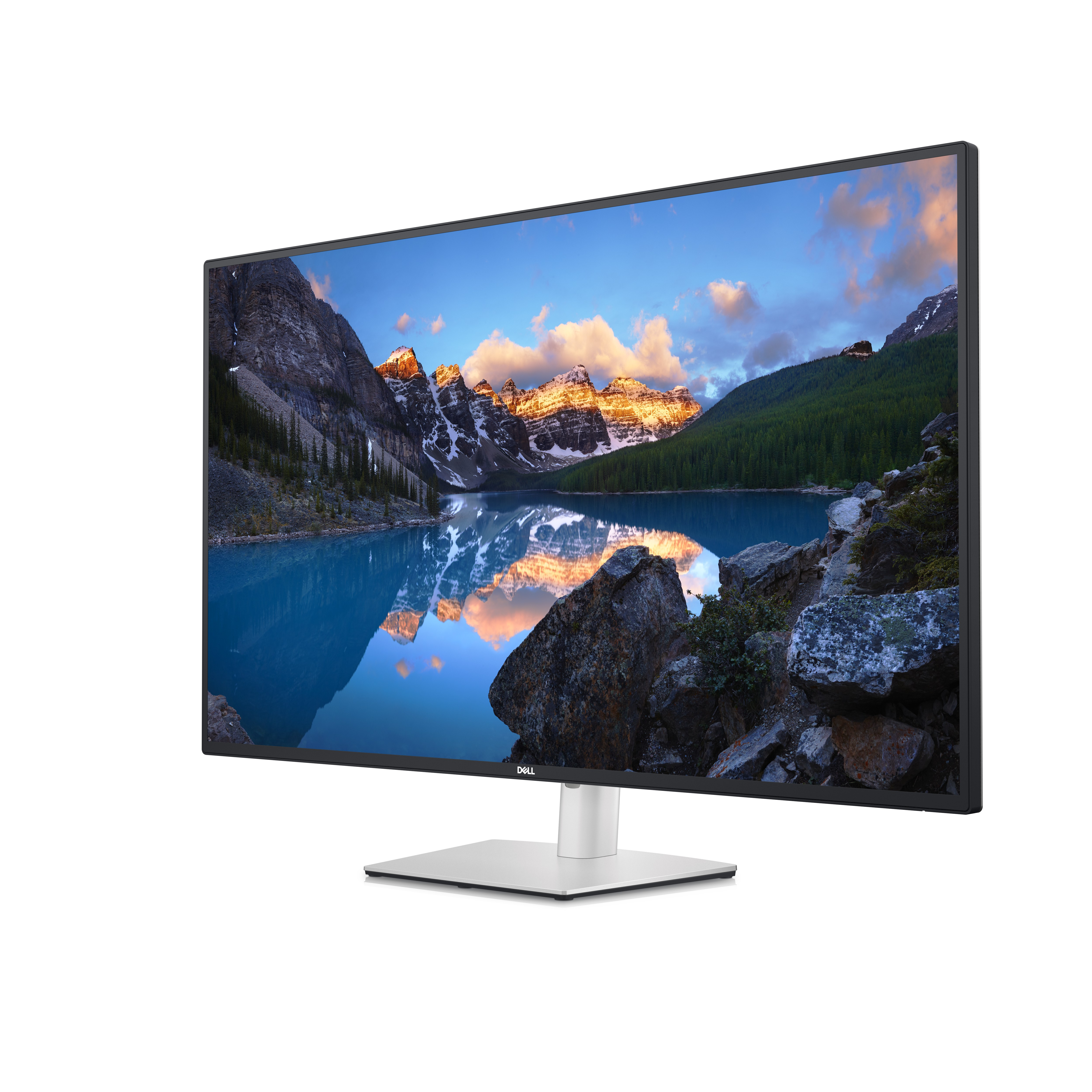 Dell-Monitor zeigt eine Bergseeszene mit Spiegelungen. Felsen und Bäume befinden sich im Vordergrund.