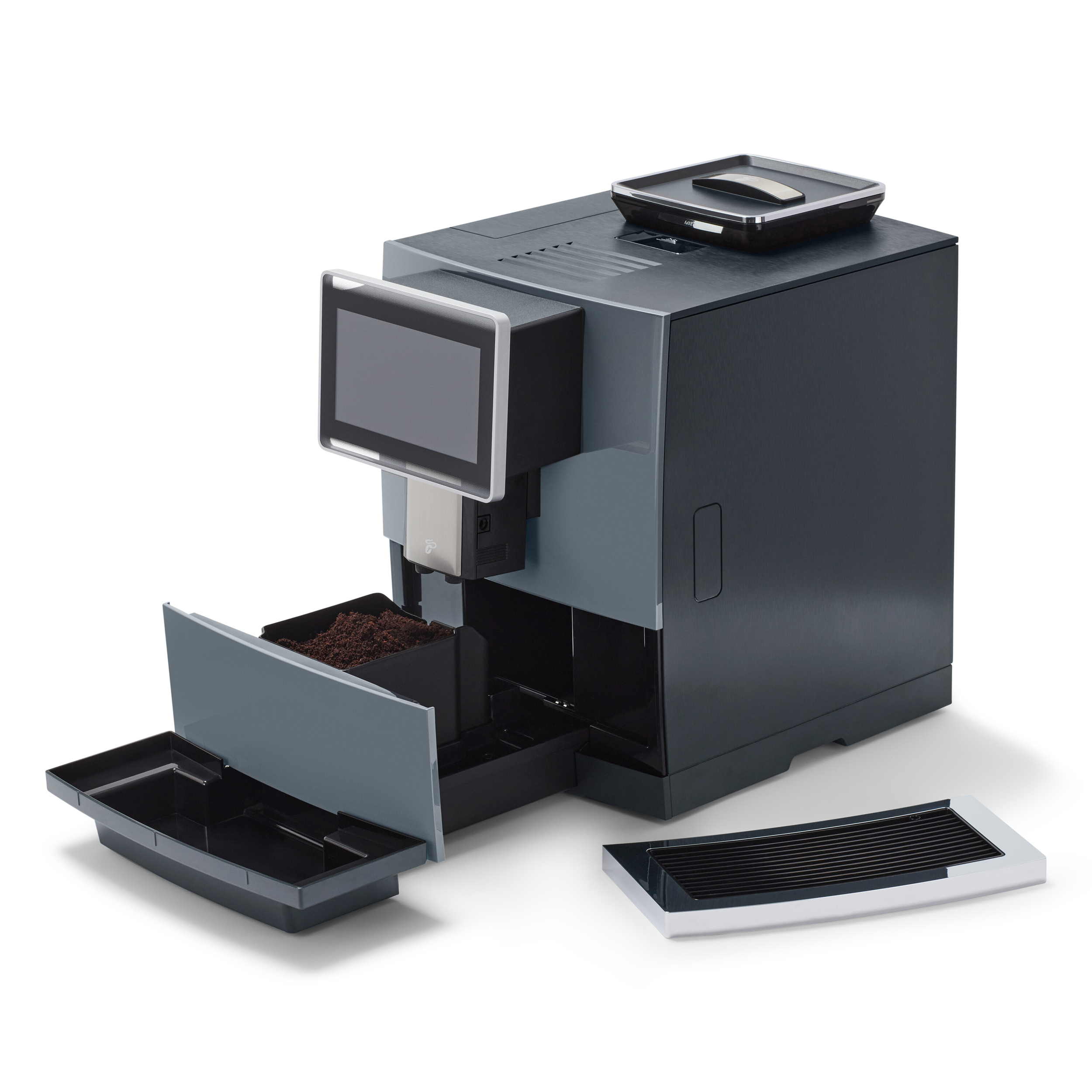 Eine dunkelgraue Kaffeemaschine mit Touchscreen, offener Schale und separater schwarzer Schale. Kaffeepulver liegt in einer offenen Schale.