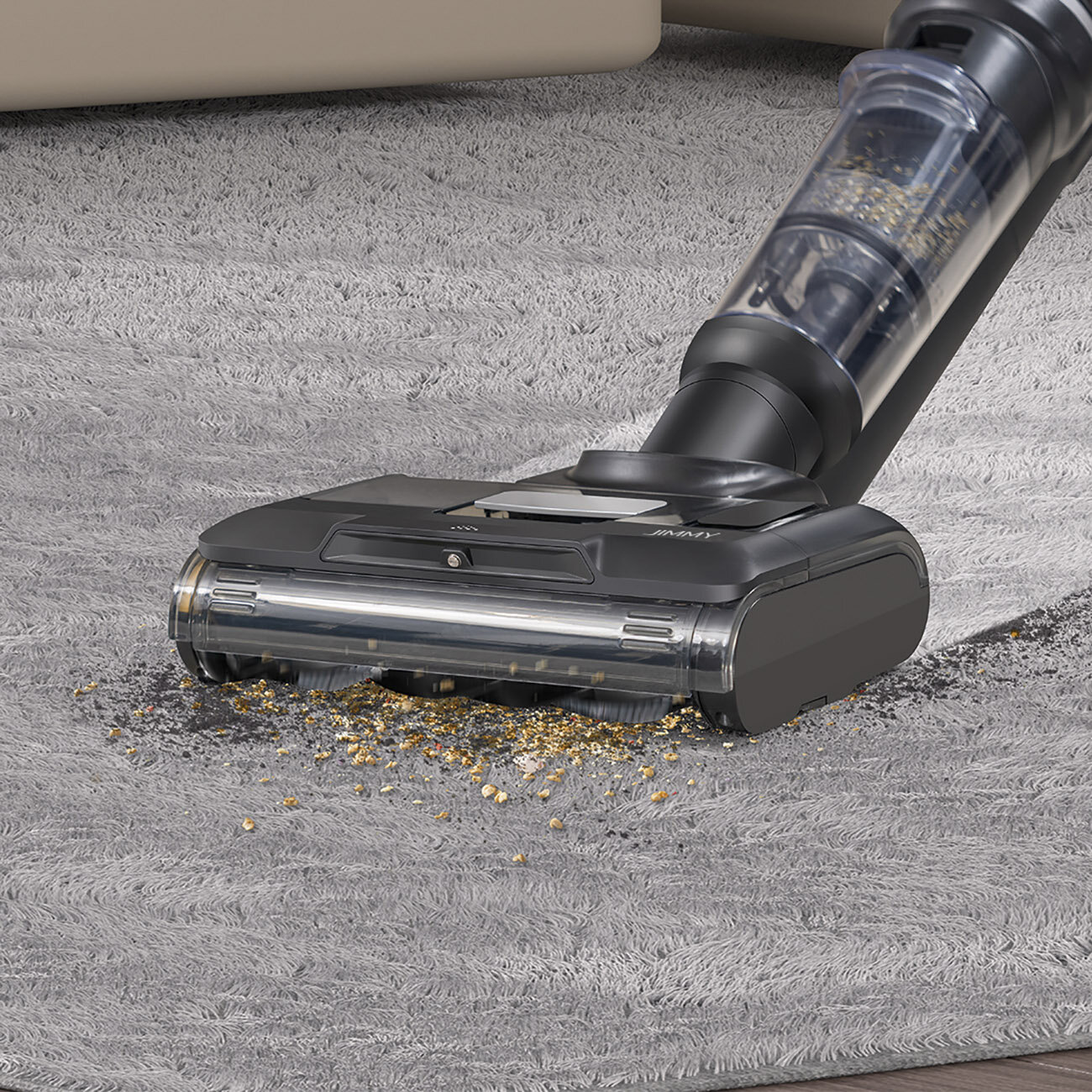 Czarny i przezroczysty odkurzacz czyści szary dywan. Na dywanie widać zanieczyszczenia, które są wciągane przez odkurzacz.