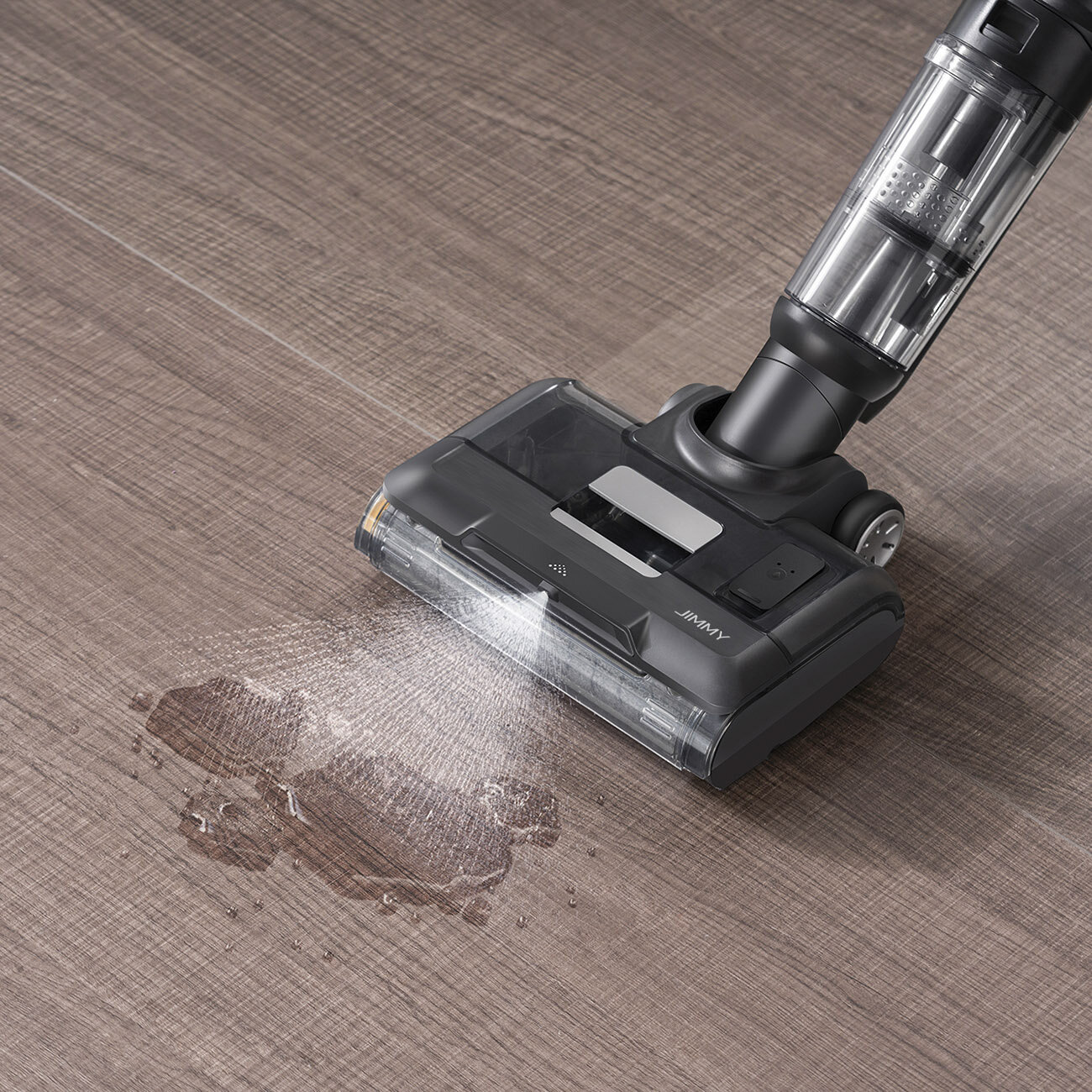 Czarno-szary odkurzacz czyści wodę z drewnianej podłogi. Woda jest rozlana jak rozprysk.