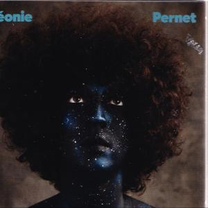 Eine Person mit blauer Haut und Glitzer im Gesicht, hat einen großen Afro. Der Name 'Leonie Pernet' steht oben.