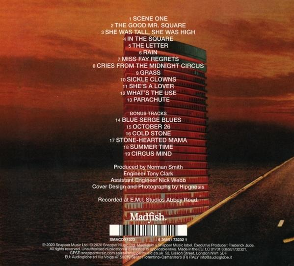 CD-Cover mit Titelliste und Credits. Ein hohes, rotbraunes Gebäude steht im Mittelpunkt. Der Hintergrund ist ein Sonnenuntergang. Straße im Vordergrund.