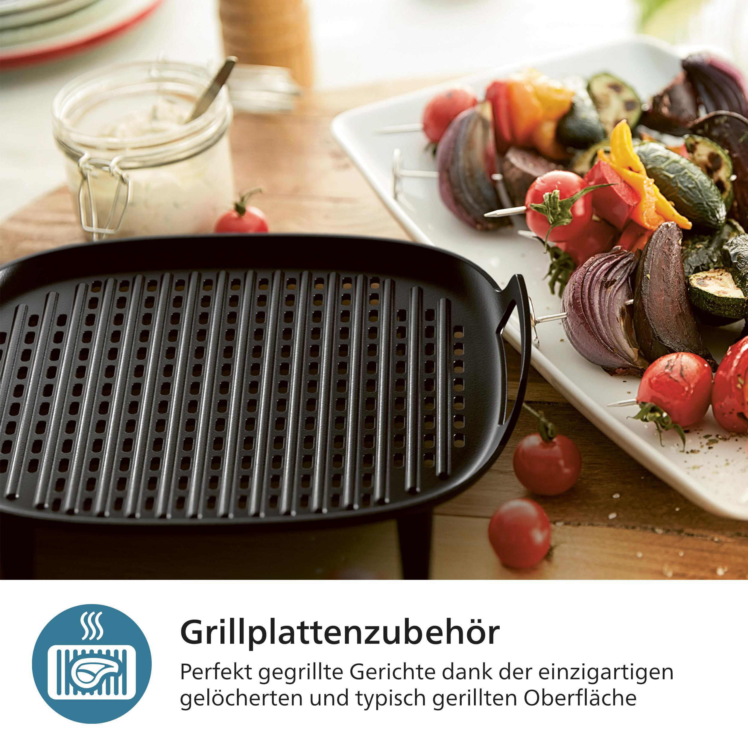 Auf einer Holzoberfläche befindet sich eine schwarze Grillpfanne. Gegrilltes Gemüse auf Spießen und ein Glas Soße.