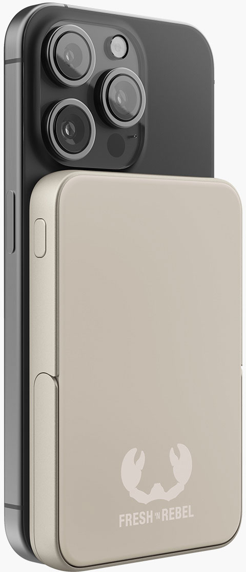 Un smartphone avec plusieurs caméras est fixé à une batterie externe beige. La batterie externe porte un logo indiquant 'FRESH 'N REBEL'.