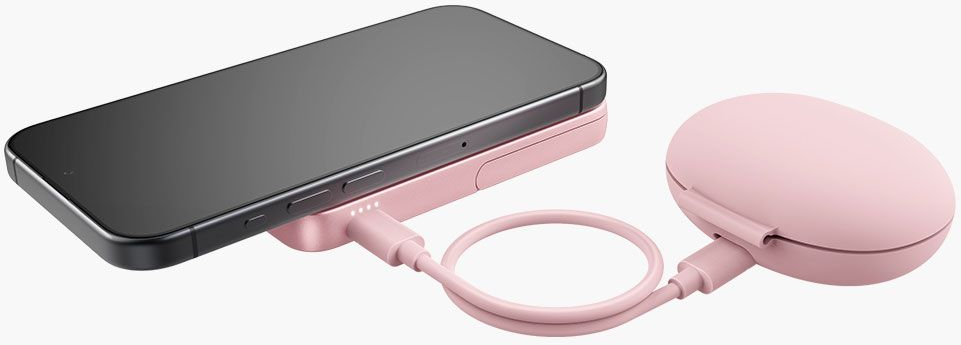 Un smartphone noir se charge sur un socle de charge rose. Un chargeur portable rose est connecté via un câble rose.