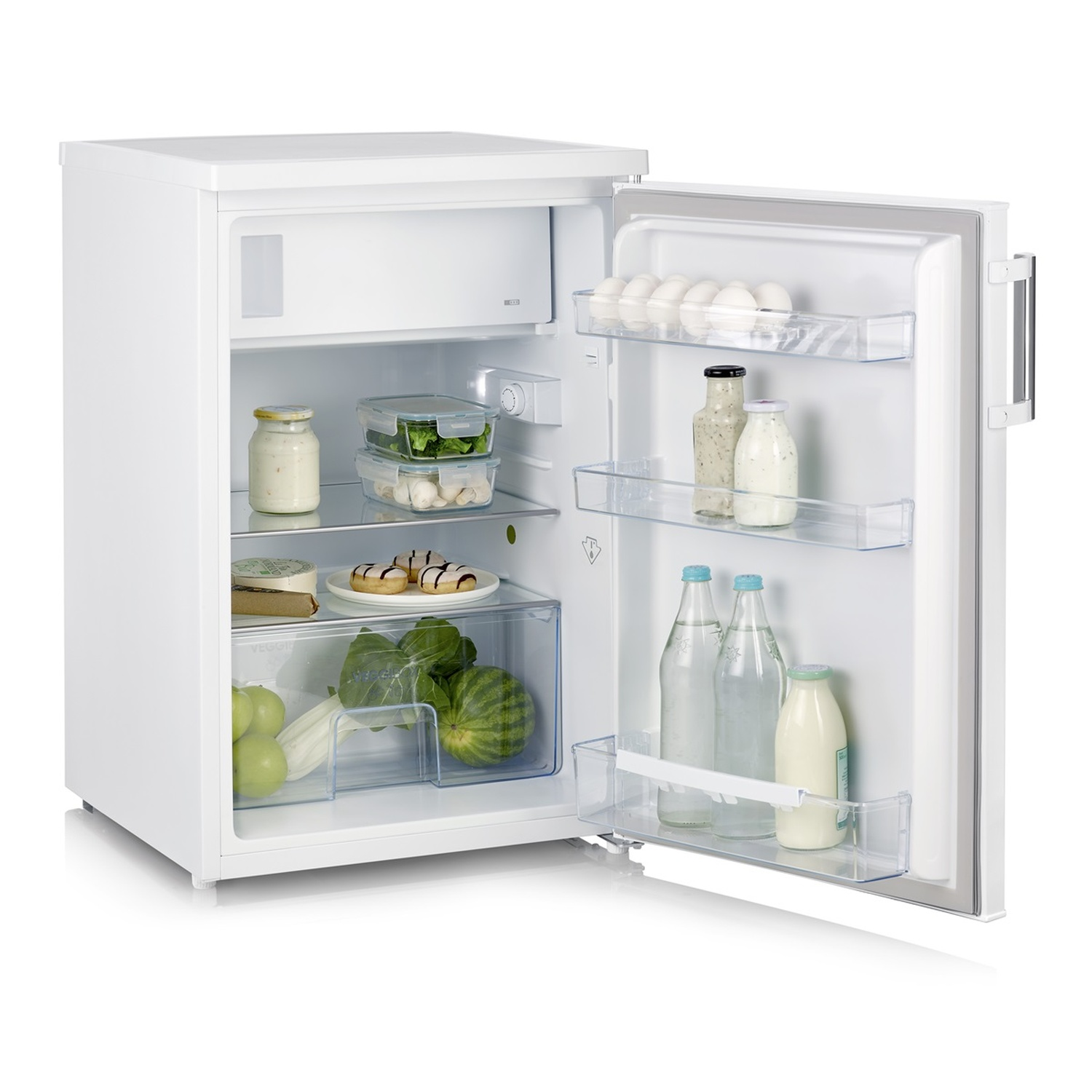 Mini réfrigérateur blanc ouvert avec de la nourriture à l'intérieur : œufs, bouteilles, aliments, fruits et légumes.