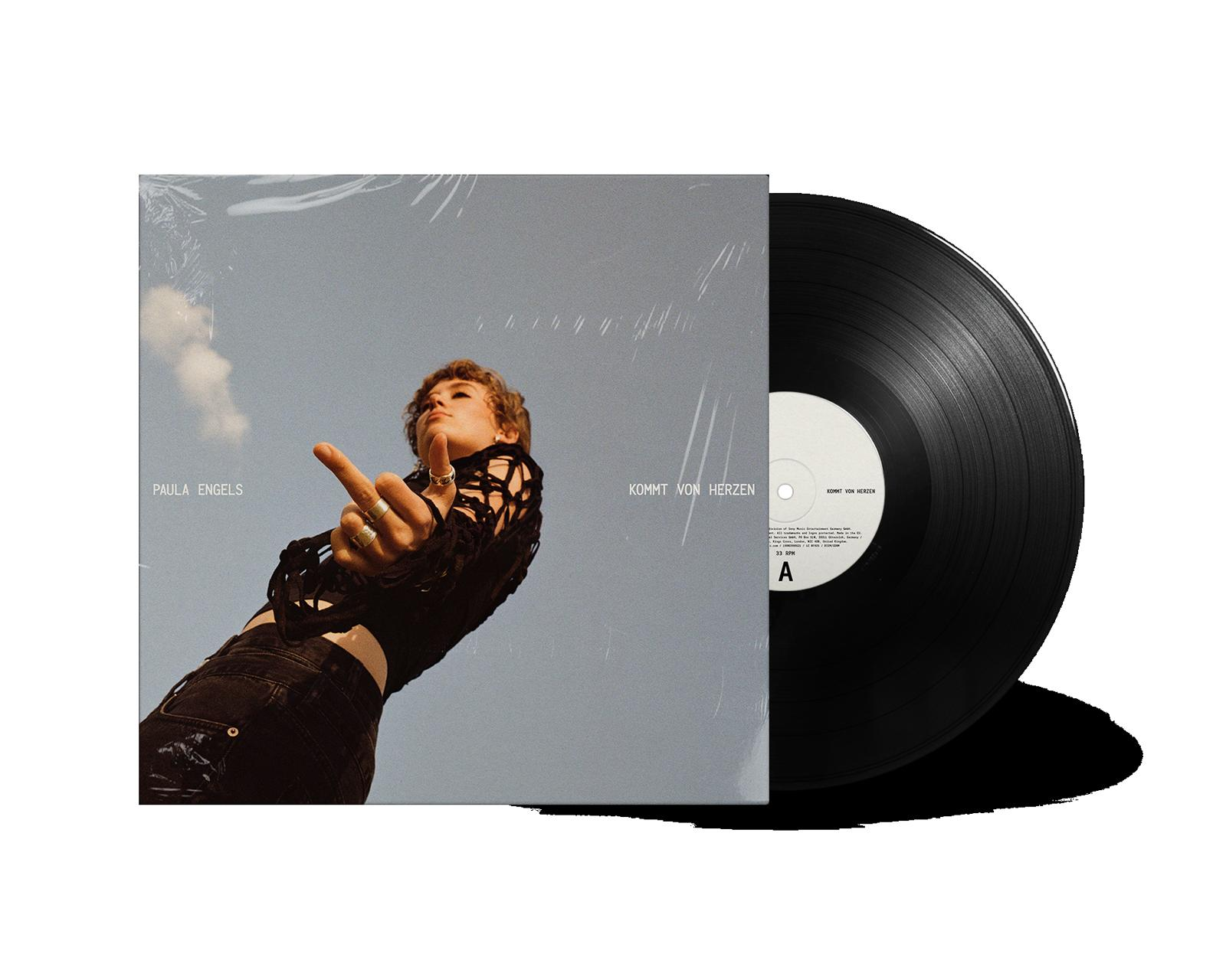 Albumcover mit zeigender Frau. Albumtitel ist 'Kommt von Herzen'. Vinylplatte neben dem Cover.