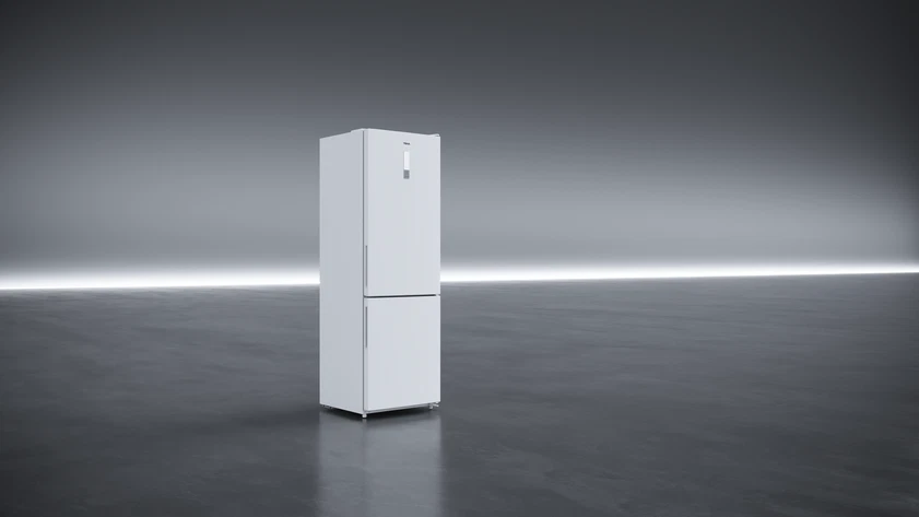 Un refrigerador blanco sobre un fondo gris con luz horizontal. El suelo es gris oscuro.