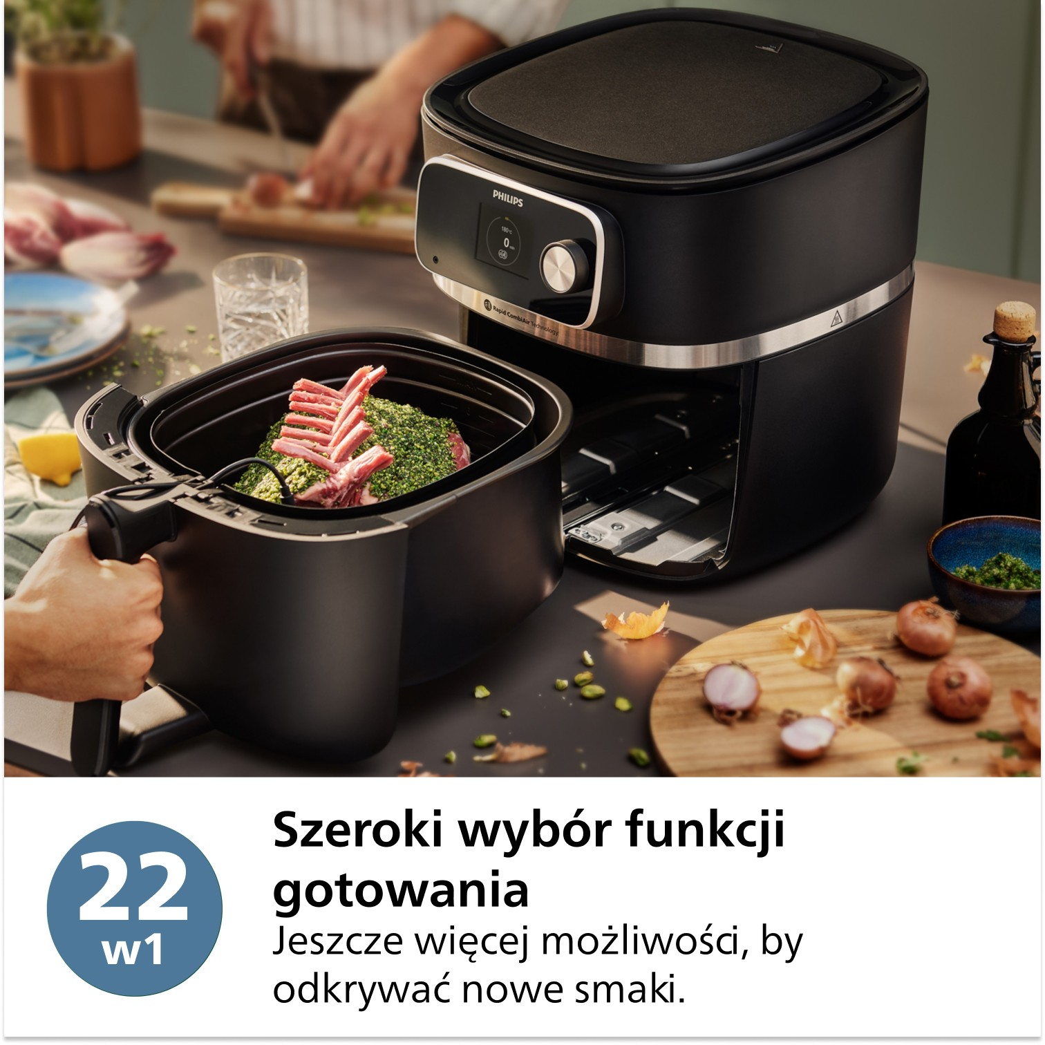 Frytownica powietrzna z żeberkami przyprawionego mięsa w koszu. Cebula i inne składniki leżą na drewnianej desce. Osoba trzyma kosz.