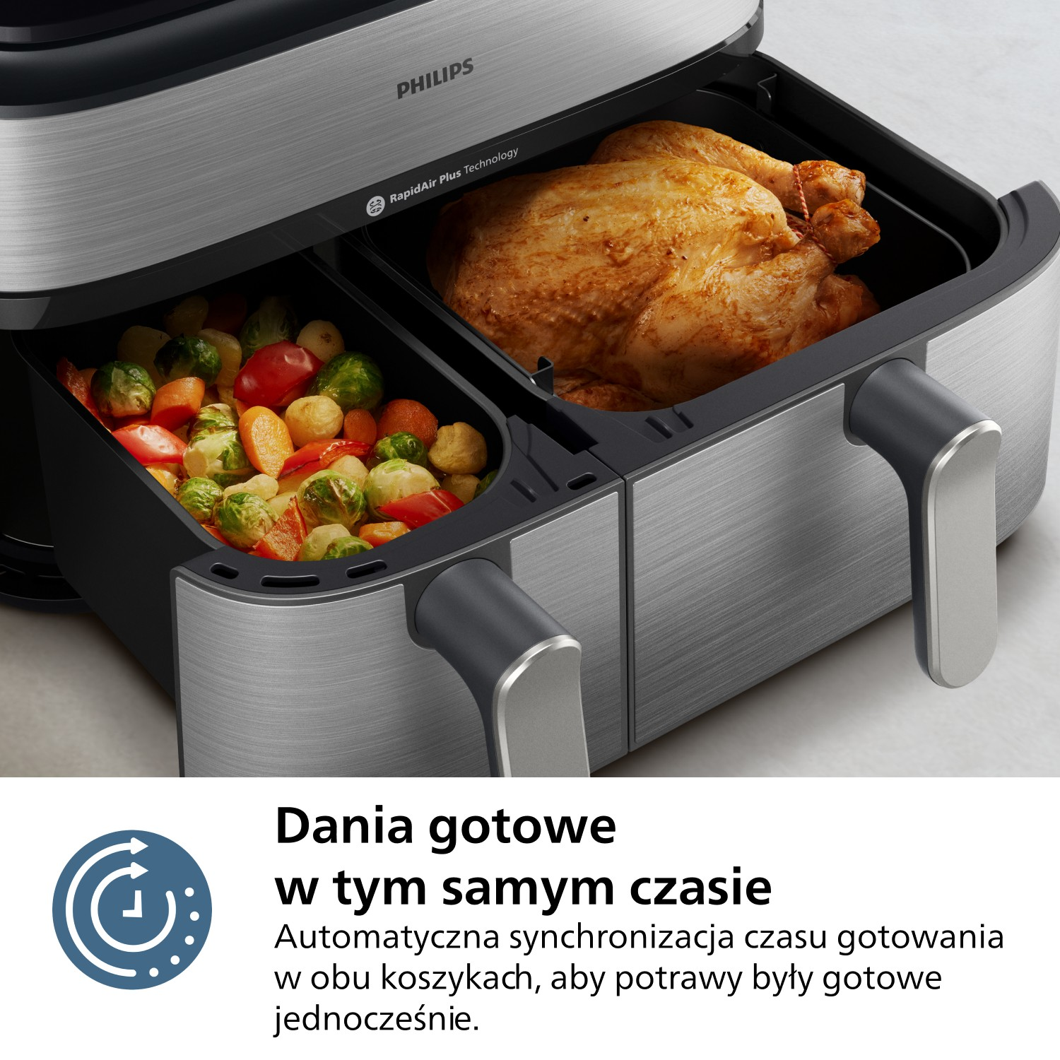 Frytownica powietrzna z pieczonym kurczakiem w jednym pojemniku i warzywami w drugim. Widoczna marka Philips.