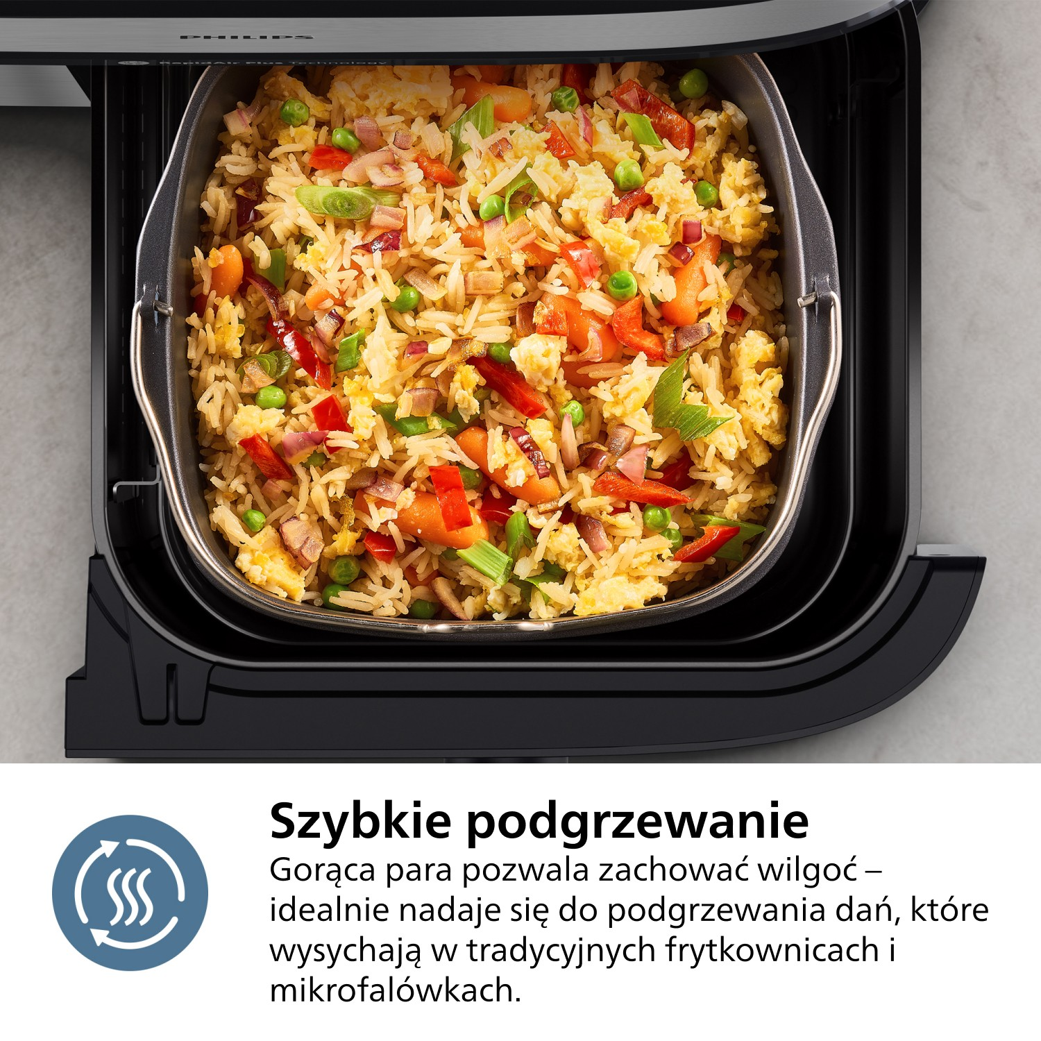 Zbliżenie na smażony ryż z warzywami w czarnej frytkownicy powietrznej. Frytownica jest otwarta, odsłaniając jedzenie. Tło jest szare.