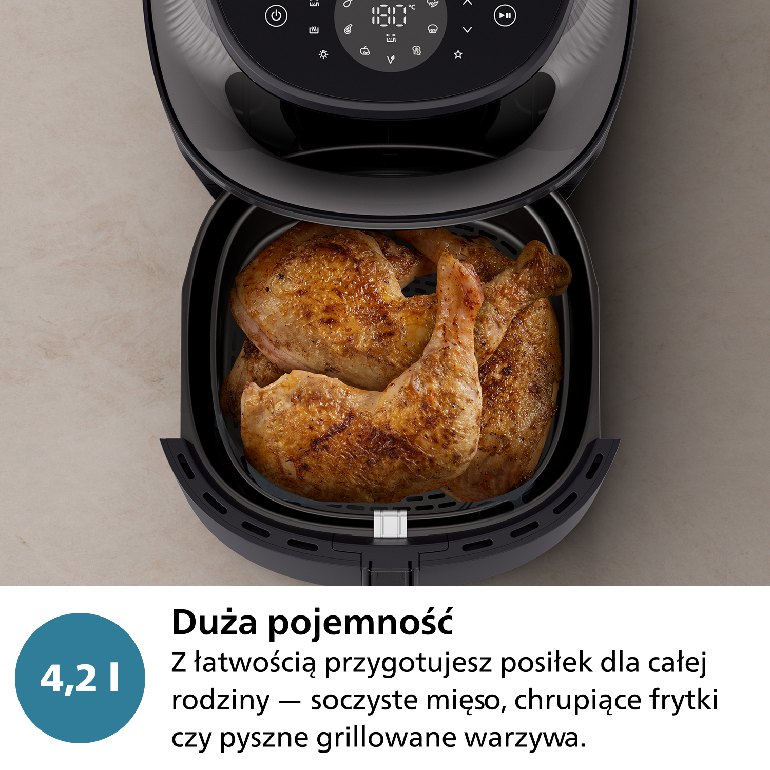 Frytownica powietrzna z ugotowanymi kawałkami kurczaka w środku. Frytownica jest czarna, z cyfrowym wyświetlaczem. Jest niebieskie koło z liczbą 4,2 I.