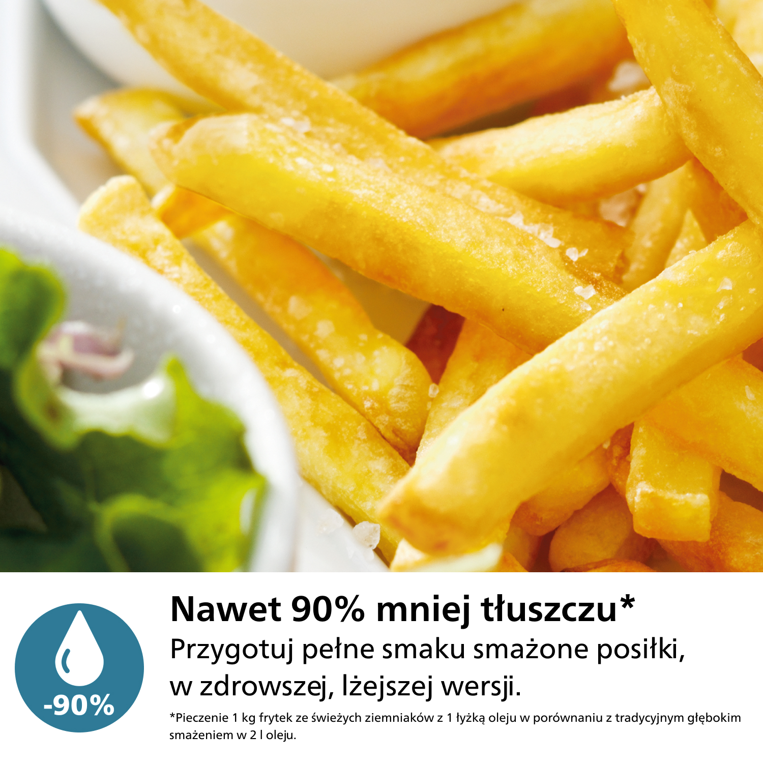 Zbliżenie złotych frytek z widoczną solą. Misa z zieloną sałatą jest w lewym dolnym rogu.