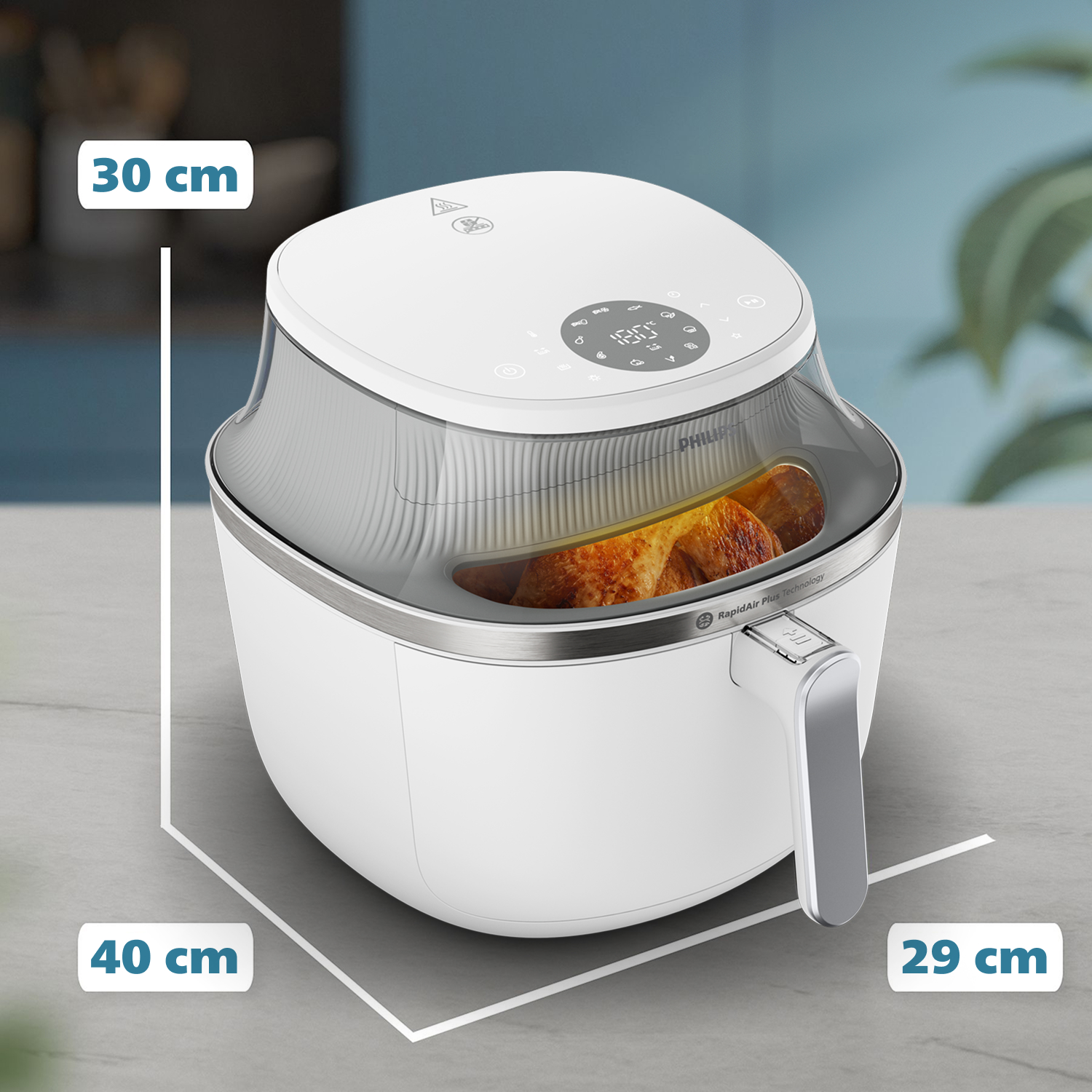 Biała frytkownica Philips z przezroczystą pokrywą, pokazuje pieczonego kurczaka. Wymiary: 30x40x29 cm. Na szarej powierzchni.