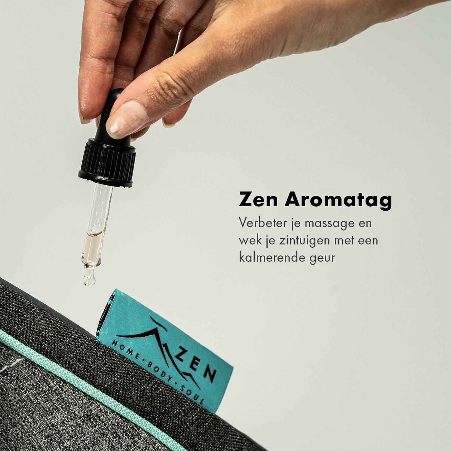 Main tenant une pipette au-dessus d'un tapis gris avec une étiquette turquoise indiquant 'Zen Home Body Soul'.