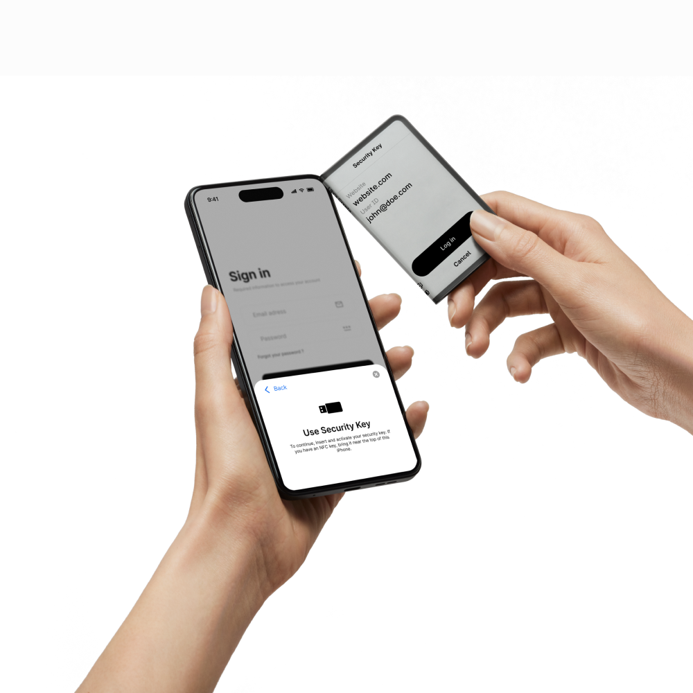Manos sosteniendo un teléfono y una llave de seguridad. El teléfono muestra una pantalla de inicio de sesión y una indicación para usar la llave.