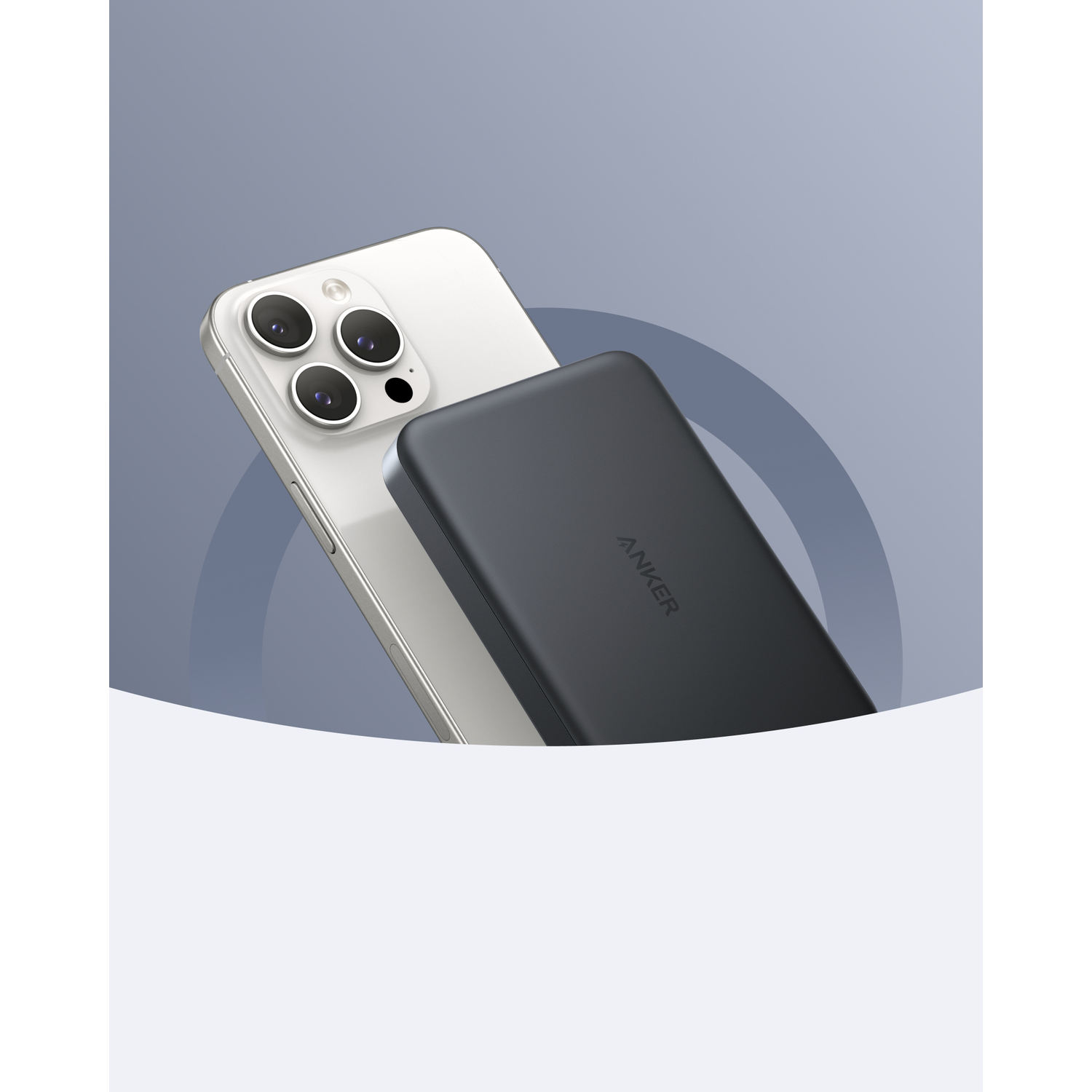A white iPhone with a black Anker power bank. The phone has four camera lenses. The power bank is dark gray and has the Anker logo.