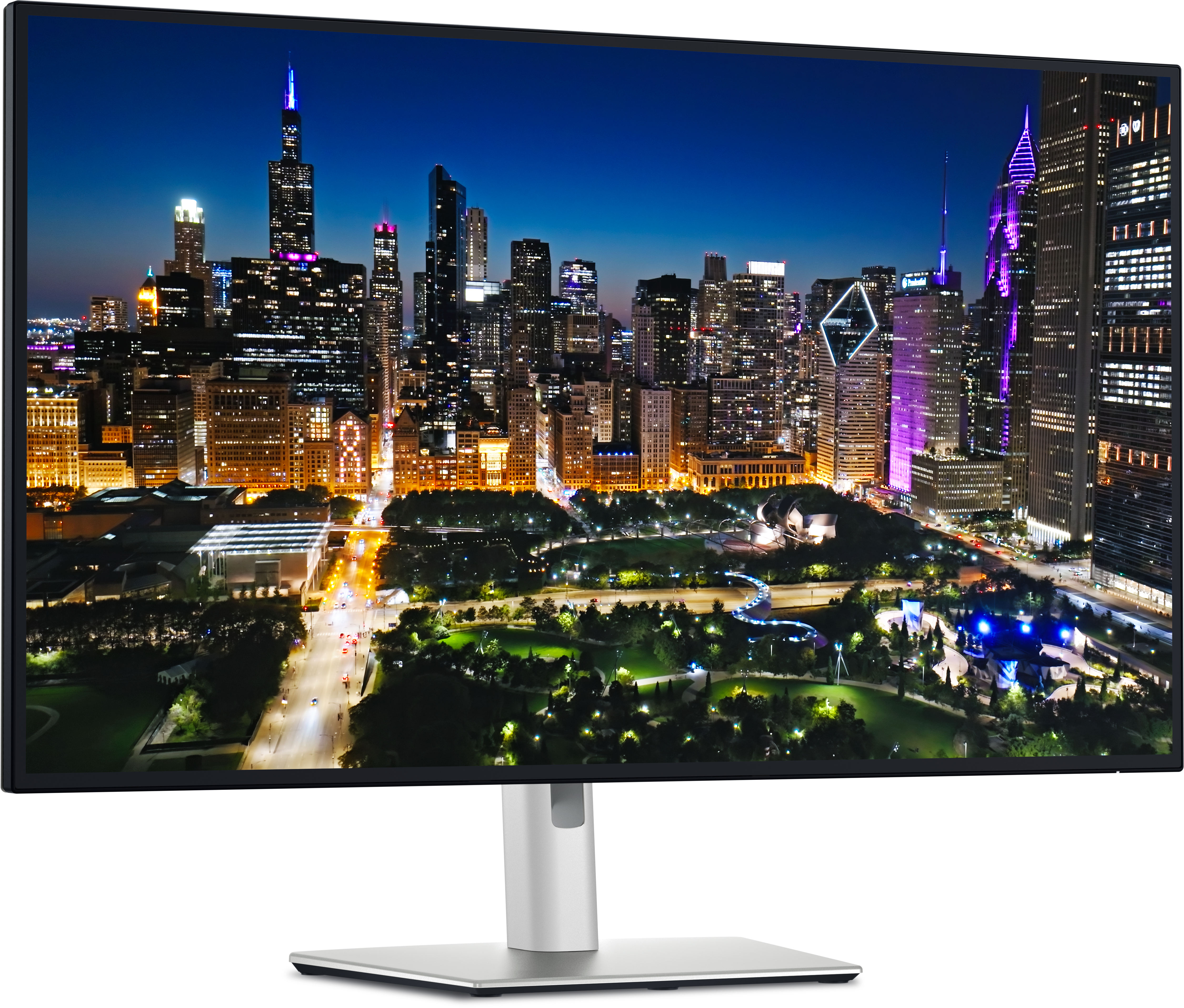 Ein Computermonitor zeigt eine nächtliche Skyline mit beleuchteten Gebäuden, grünen Parks und einem dunkelblauen Himmel.