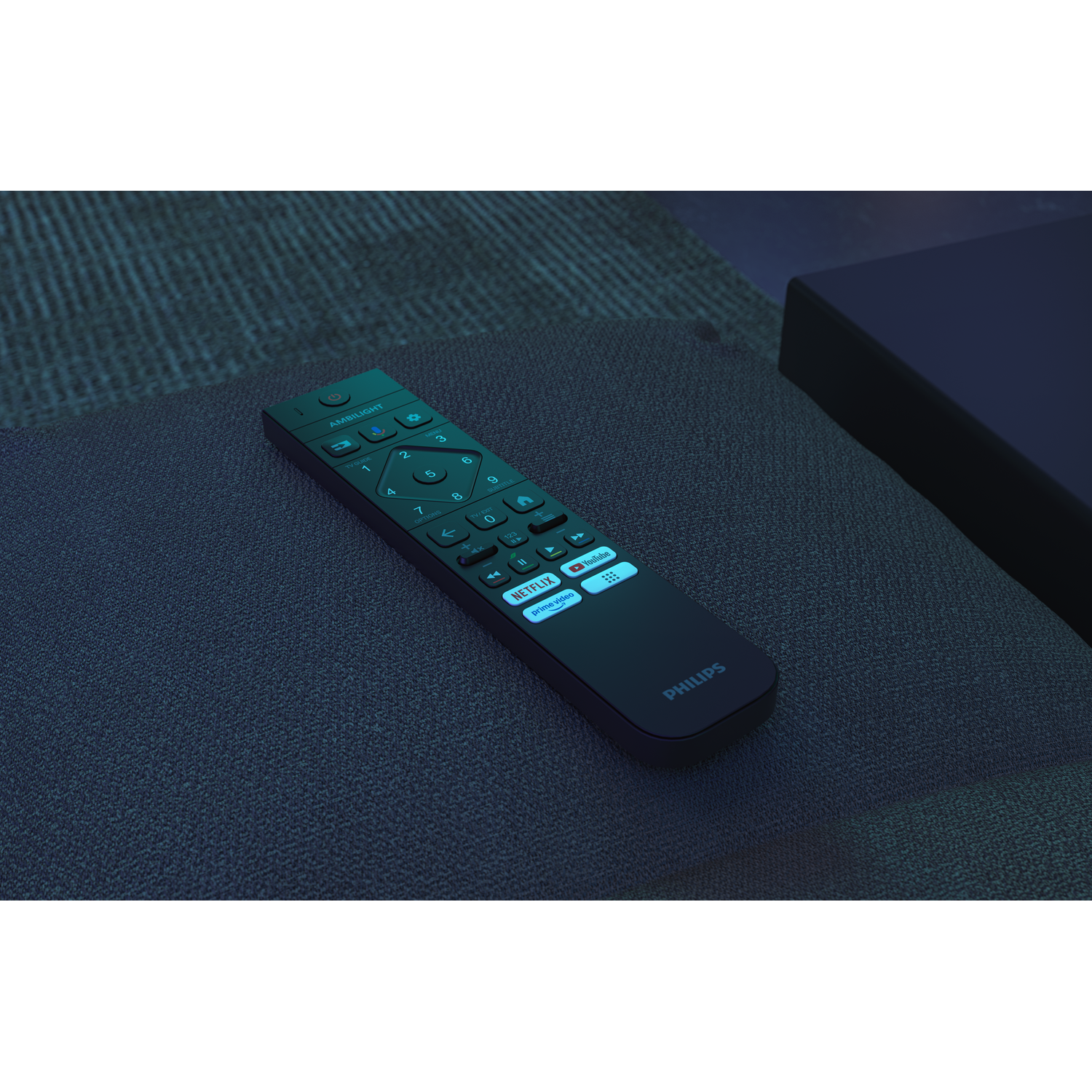 A Philips remote control lies on a dark surface. The remote is black with illuminated buttons, including Netflix and YouTube access.