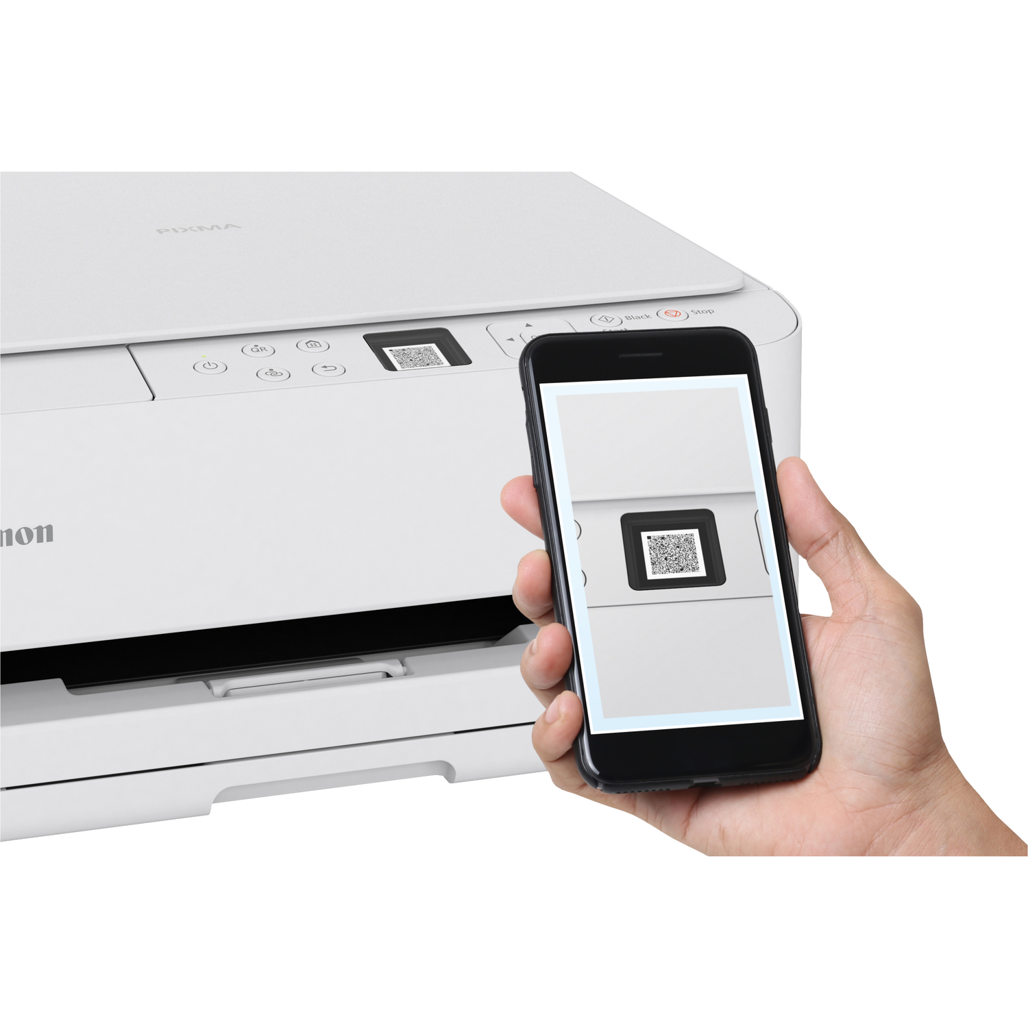 A hand holding a phone scanning a QR code on a white Canon printer. The phone shows a QR code.