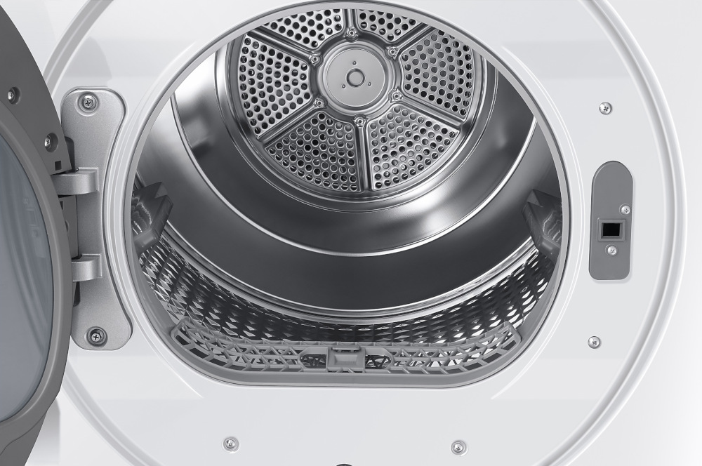 Inside of a washing machine dryer. The door is open, revealing a metal drum and a plastic filter at the bottom.