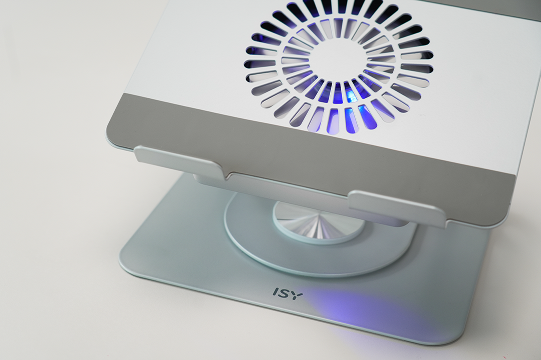 Ezüst laptopállvány ventilátorral. Fehér teteje van, ventilátorral, szürke alappal és világoskék fénnyel.
