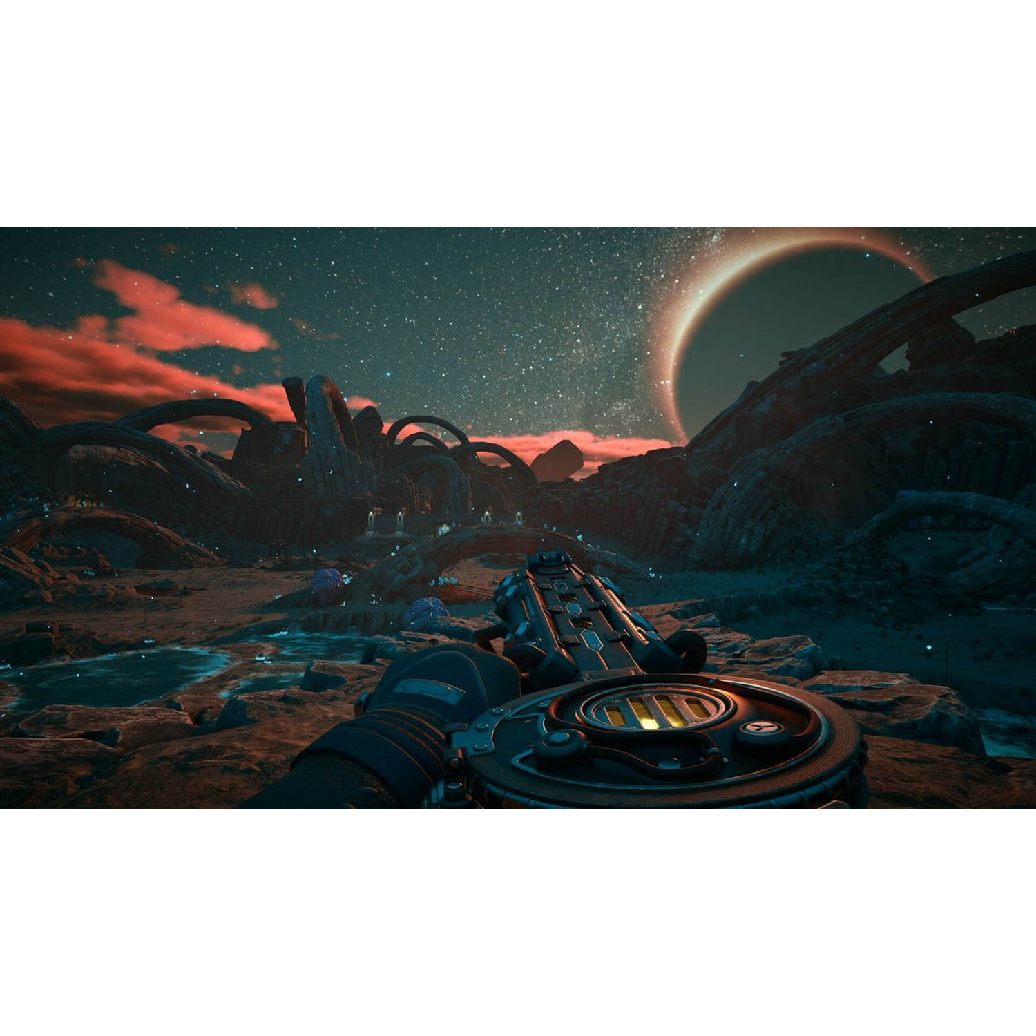 Een first-person view met een futuristisch pistool. Buitenaards landschap met rode wolken, een grote ringvormige planeet en vreemde rotsformaties.
