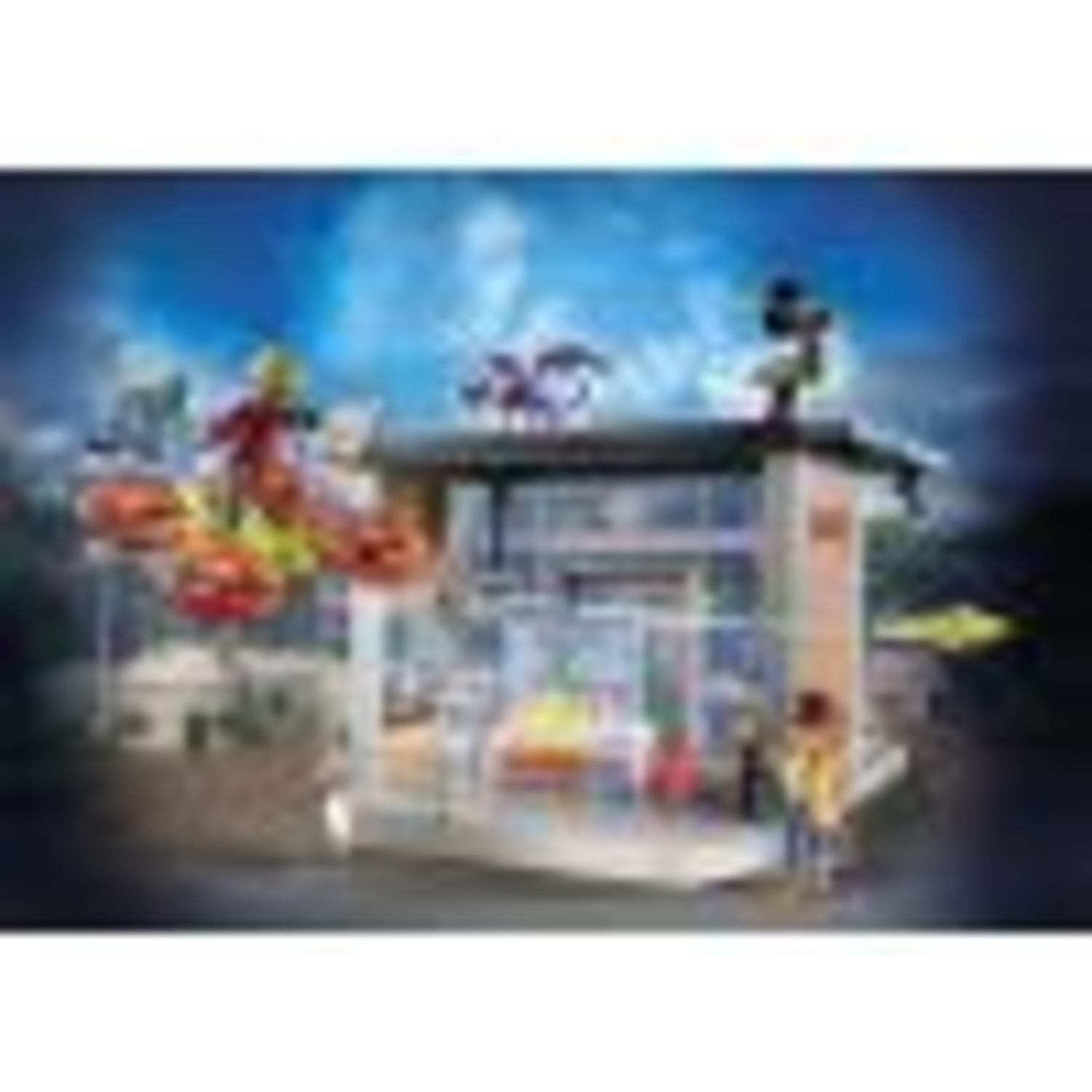 A toy amusement park set. Ferris wheel, building with figures, and a night sky background.