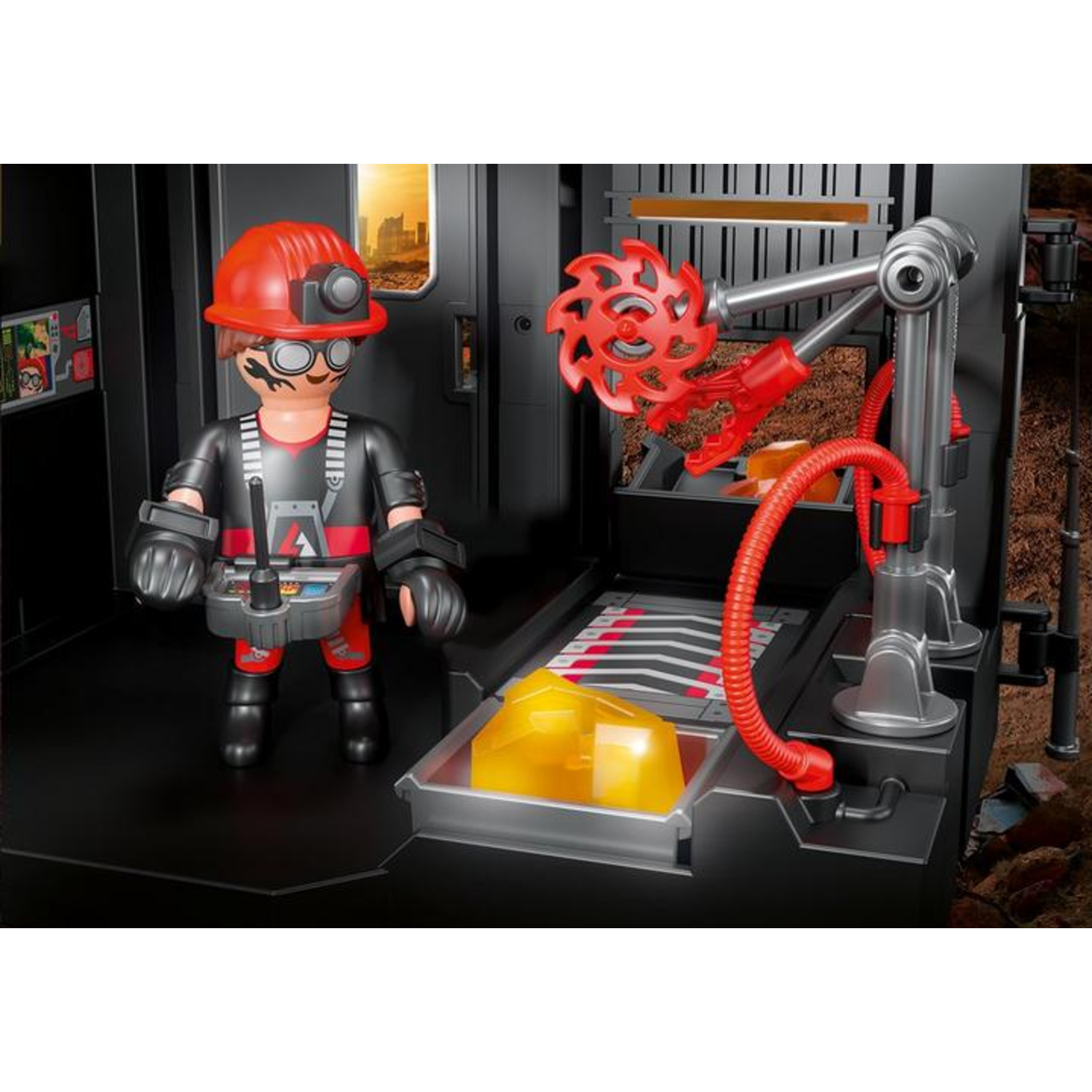 A toy figure with a red helmet and a control panel stands near a mining machine. A yellow block is on a tray.