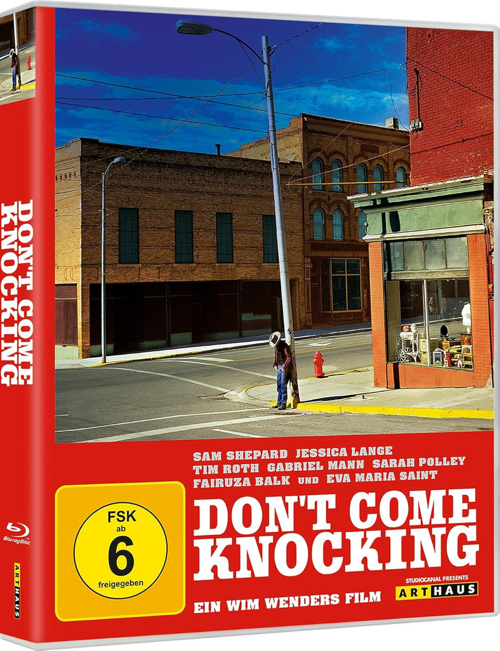 Das Filmcover zeigt einen Mann, der sich an einer Stange auf der Straße lehnt. Im Hintergrund sind Gebäude zu sehen. Der Titel lautet 'Don't Come Knocking'.
