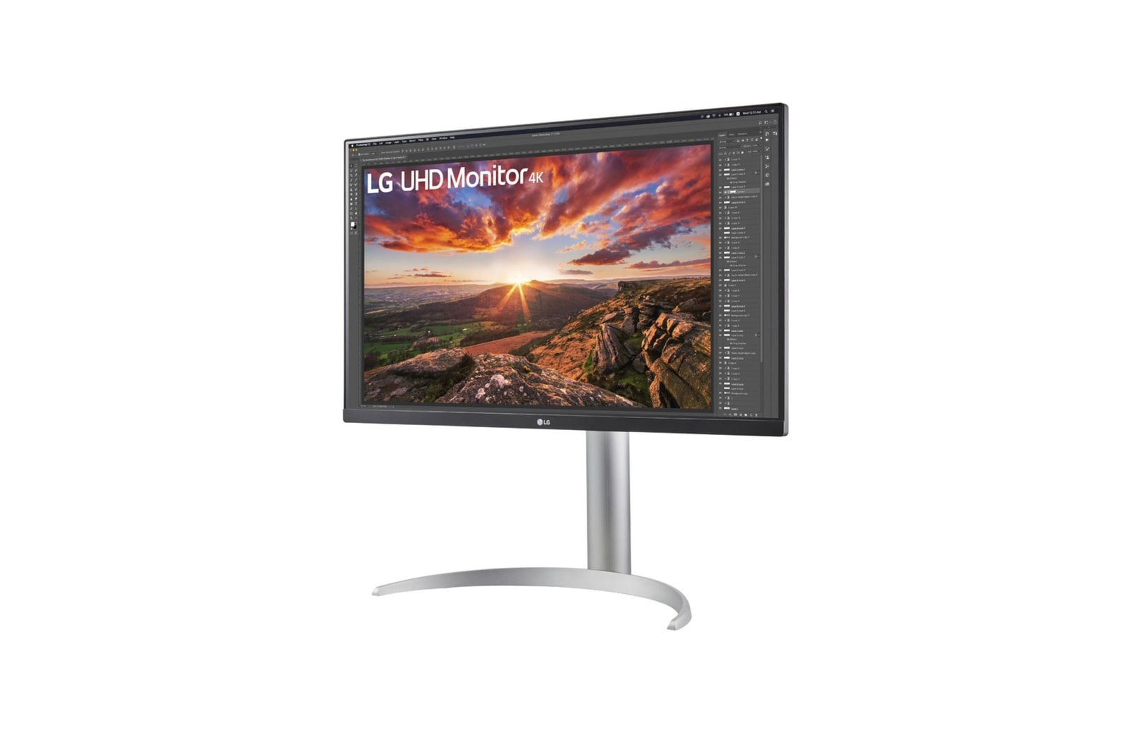 Monitor LG 4K wyświetla krajobraz z zachodem słońca. Monitor stoi na srebrnej podstawie na białym tle.