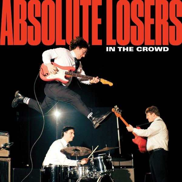 Eine Band spielt. Ein Gitarrist springt. Schlagzeuger und Bassist spielen. Text: "Absolute Losers in the Crowd".