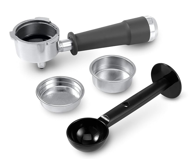 Części ekspresu do kawy. Kolba, koszyki filtrujące i czarna miarka na białej powierzchni. Kolba jest na górze.