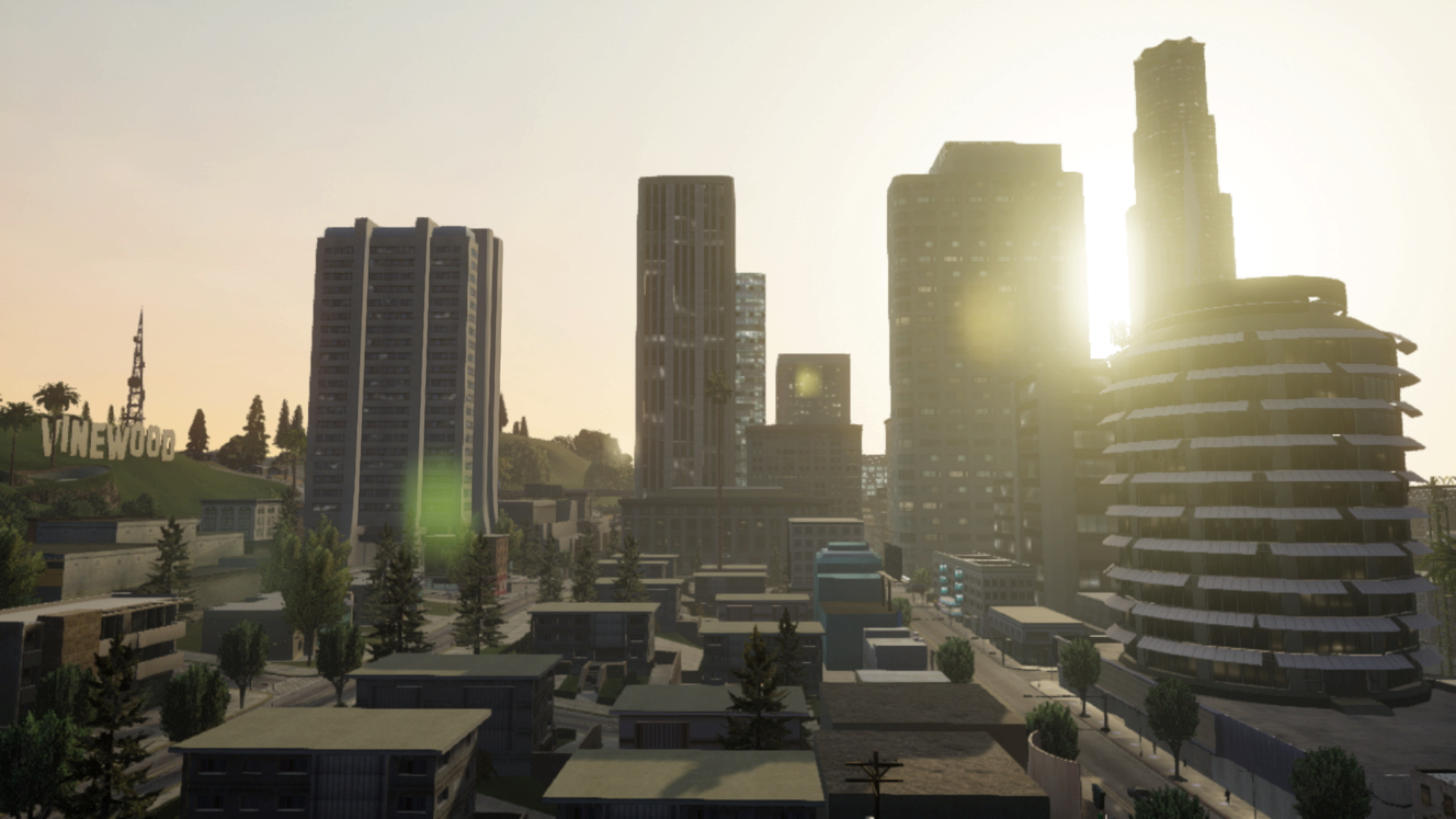 Stadtbild mit Hochhäusern, die Sonne scheint hindurch. Das Schild 'Vinewood' befindet sich im Hintergrund.