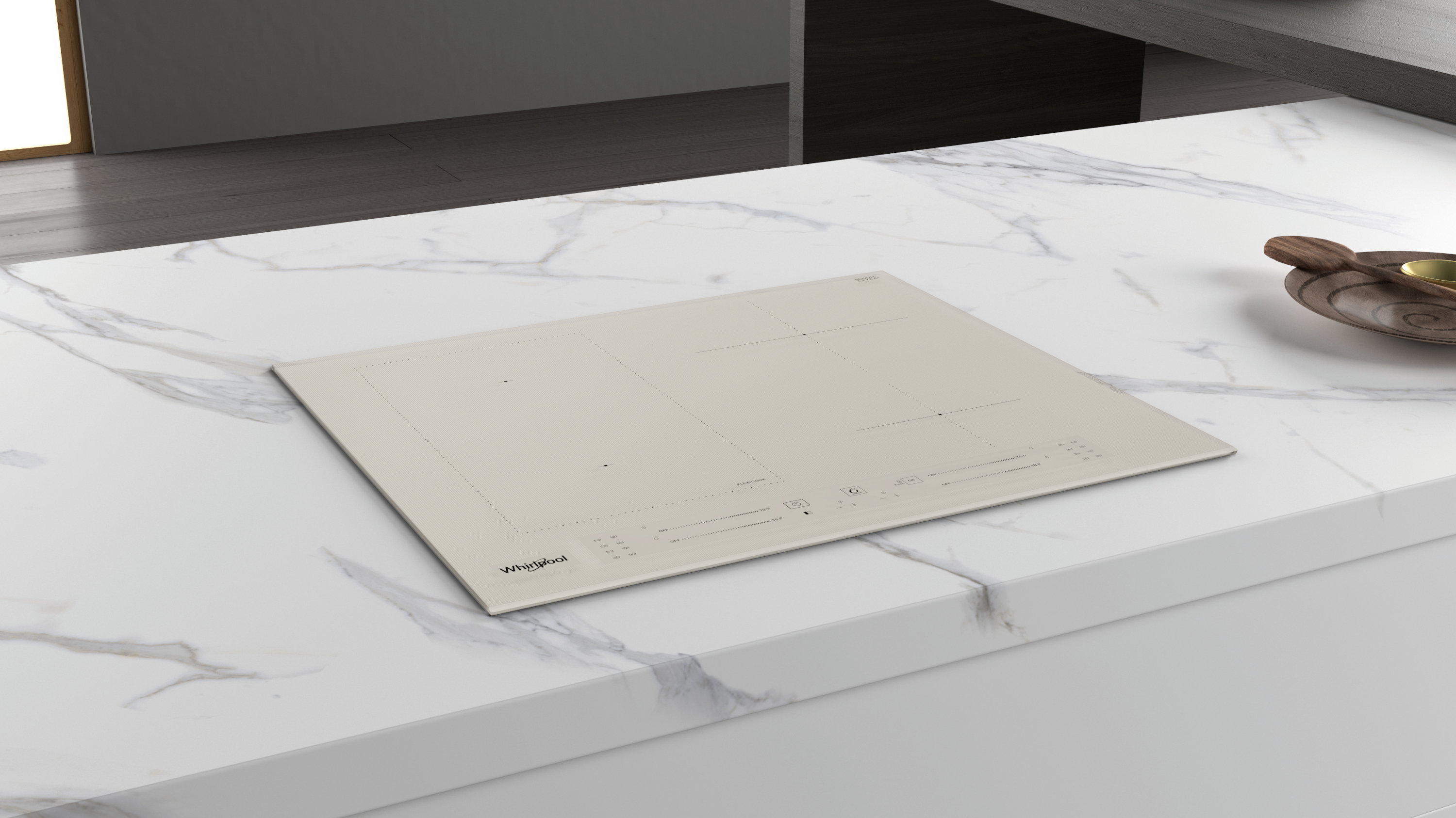 Widok z góry na beżową płytę indukcyjną Whirlpool na białym marmurowym blacie. Drewniany talerz i łyżka w tle.