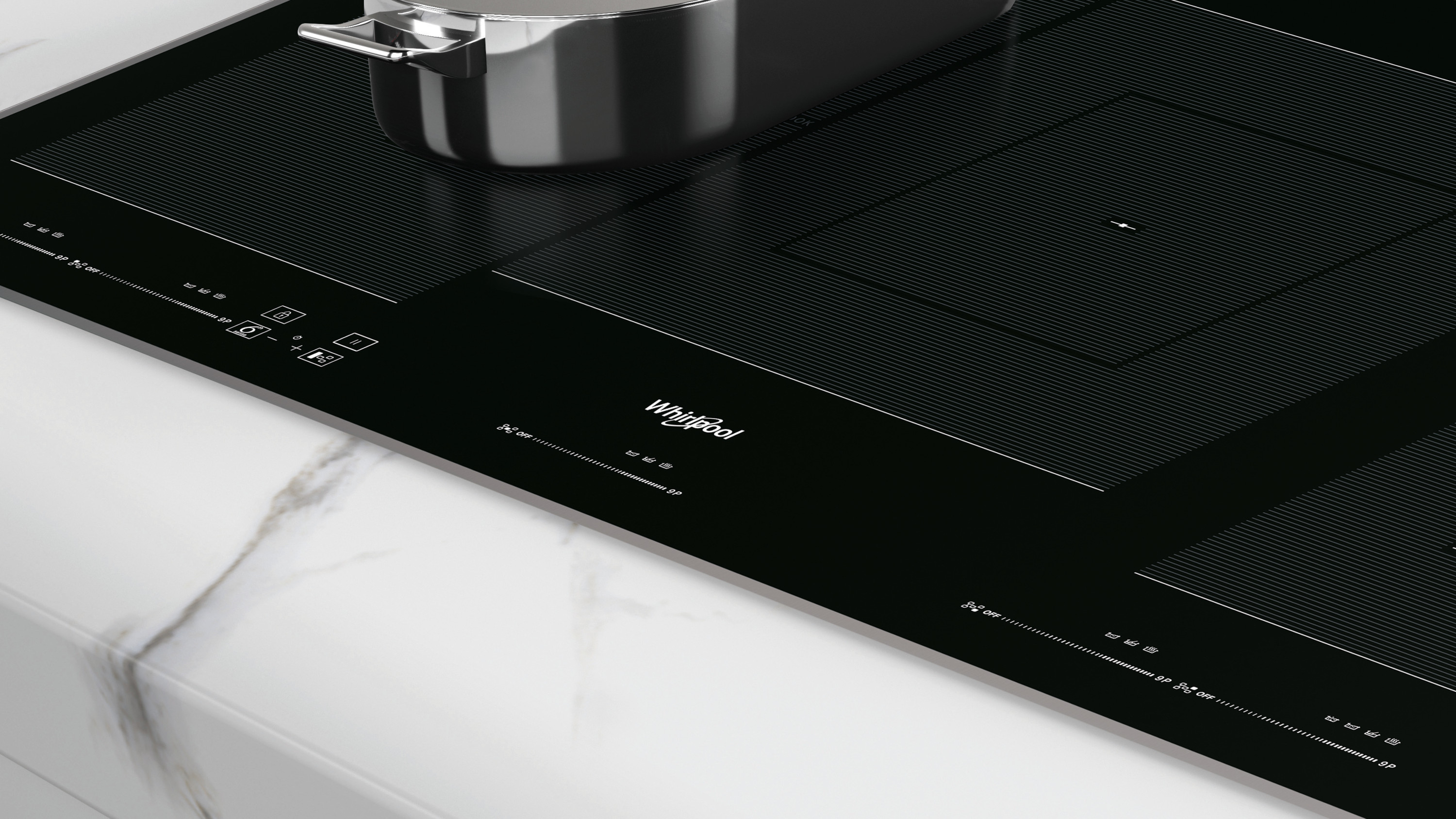 Czarna płyta indukcyjna Whirlpool ze stalowym garnkiem. Płyta znajduje się na białym marmurowym blacie.